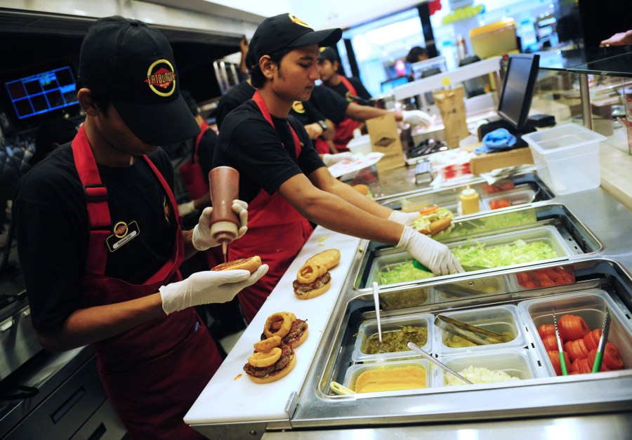 In this picture taken Jan. 10, 2013, Pakistani employees prepare food at a Fatburger location in Karachi. (Credit: Rizwan Tabassum / AFP / Getty Images)