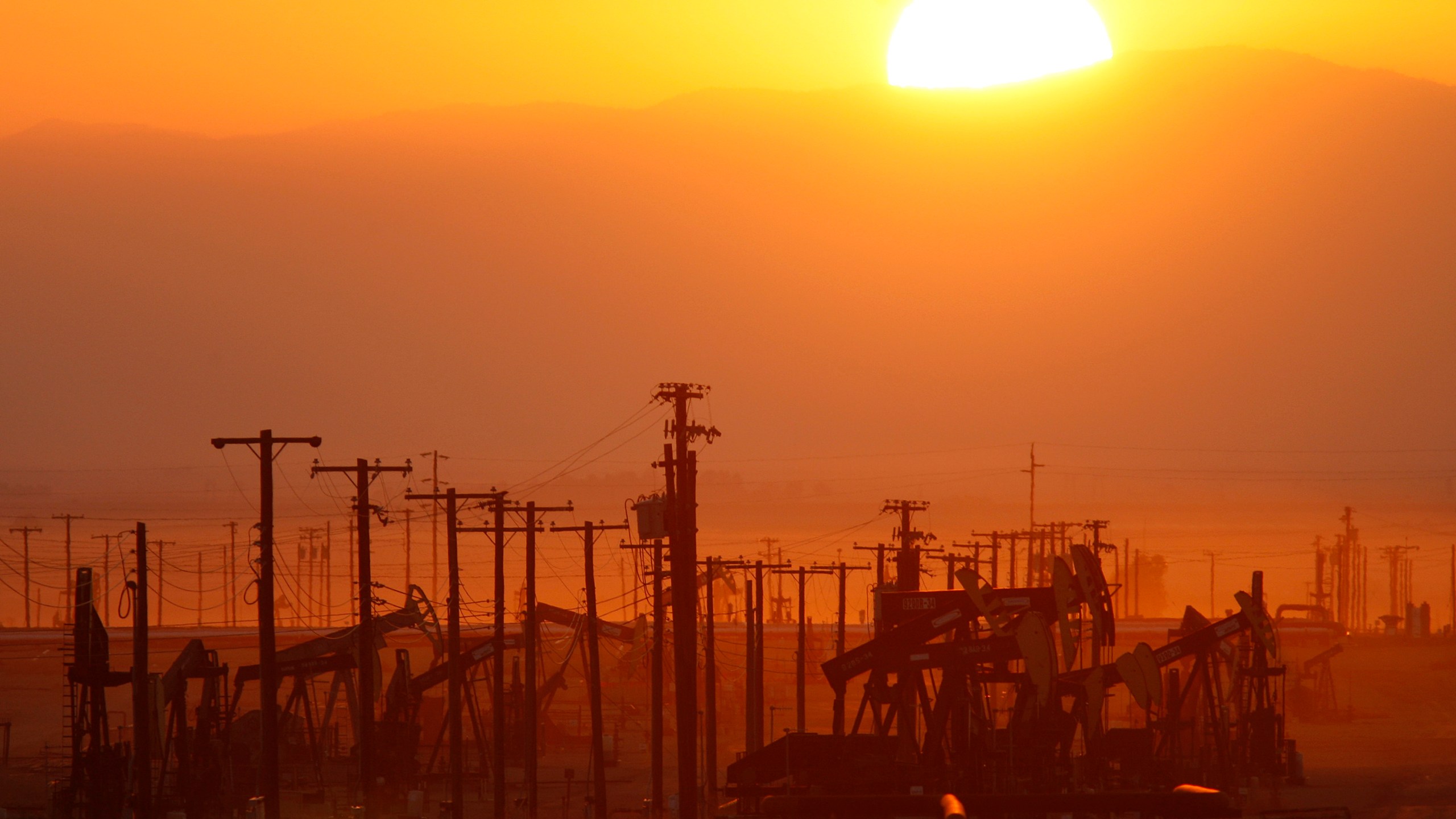 The sun rises over an oil field at the Monterey Shale formation on March 24, 2014, near Lost Hills, California. (Credit: David McNew/Getty Images)