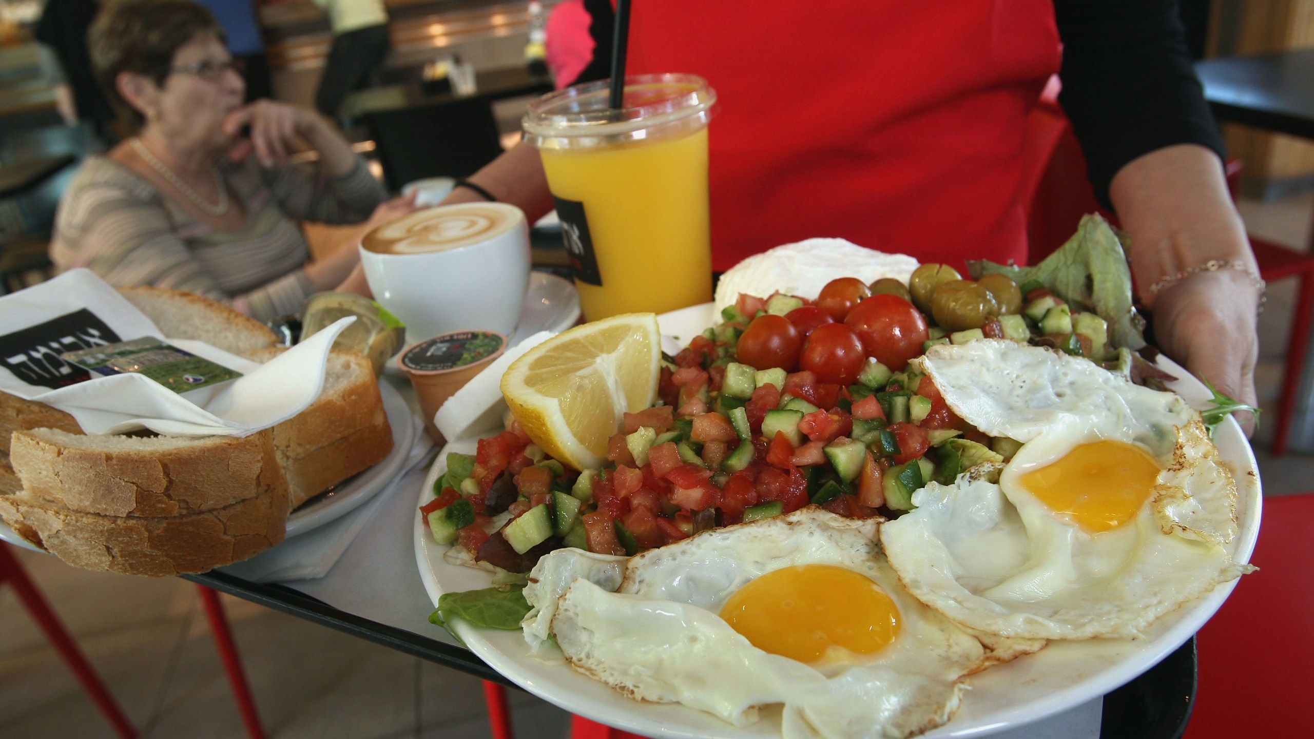 A waitress serves breakfast for two, including eggs, cheeses, salad, orange juice, coffee and fresh baked bread at the Aroma espresso bar on March 11, 2008. (Credit: David Silverman/Getty Images)