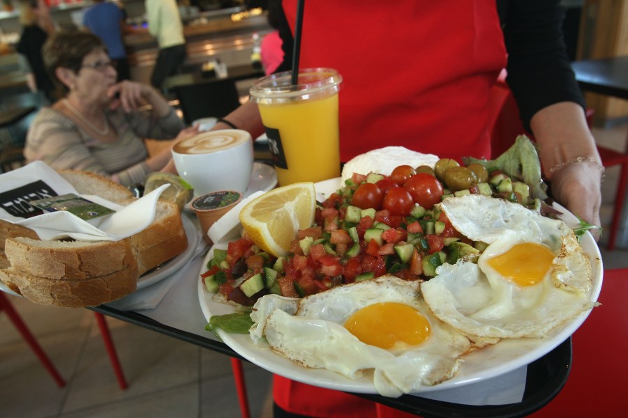 A waitress serves breakfast for two, including eggs, cheeses, salad, orange juice, coffee and fresh baked bread at the Aroma espresso bar on March 11, 2008. (Credit: David Silverman/Getty Images)