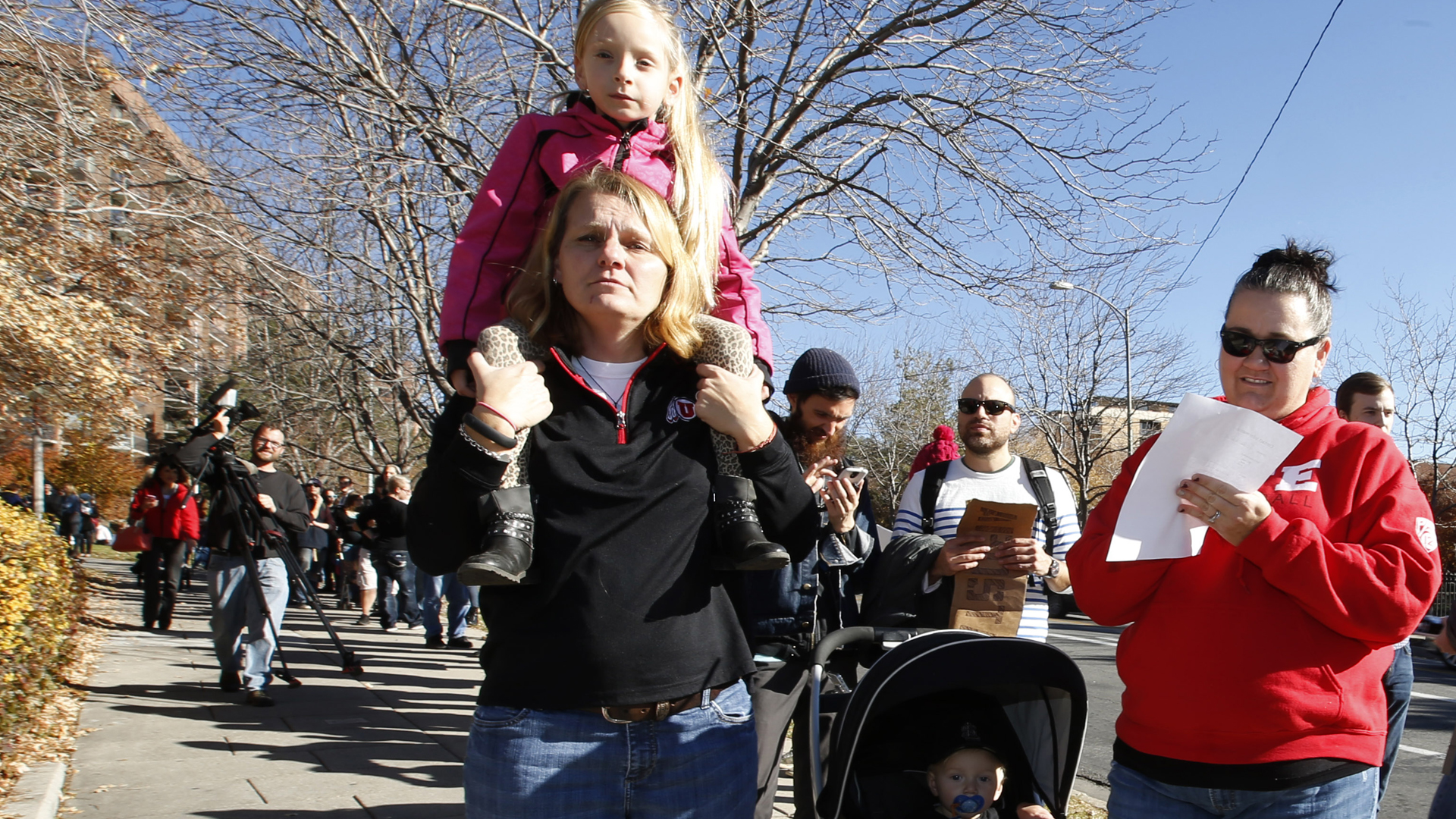 While her wife Debbie (left) and kids Chole and Cason stand in line, Trisha Allen-Gibby fills out papers for her and her family to resign from the Church of Jesus Christ of Latter-Day Saints in response to a recent change in church policy towards married LGBT same-sex couples and their children on Nov. 14, 2015, in Salt Lake City, Utah. A little over a week earlier, the Mormon church made a change in their official handbook of instructions requiring a disciplinary council and possible excommunication for same-sex couples and banning the blessing and baptism of their children into the church. (Credit: George Frey/Getty Images)