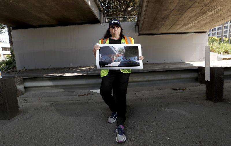 Artist Judy Baca stands in front of a wall along the 110 Freeway in downtown Los Angeles where her mural was covered by gray paint in March 2019. (Credit: Luis Sinco / Los Angeles Times)