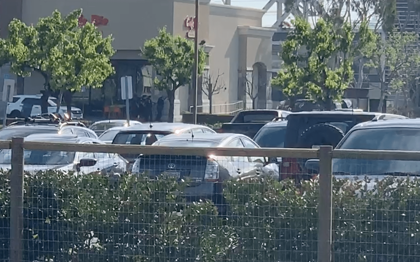 Police officers stand by a building during a shootout in Manhattan Beach on April 7, 2019. (Credit: Kevin McCullough)