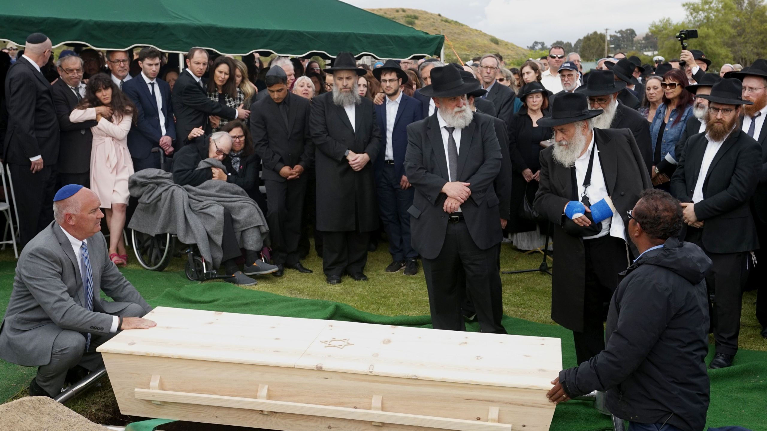 Mourners look over a coffin during the burial service for Lori Gilbert Kaye, who was killed in the Chabad of Poway Synagogue shooting, at El Camino cemetery in San Diego on April 29, 2019. (Credit: SANDY HUFFAKER/AFP/Getty Images)