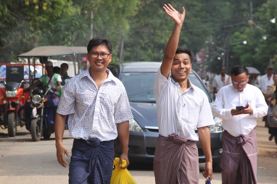 Reuters journalists Kyaw Soe Oo, right, waves beside colleague Wa Lone as they walk out of Insein prison after being freed in a presidential amnesty in Yangon, Myanmar, on May 7, 2019. (Credit: AFP / Getty Images)