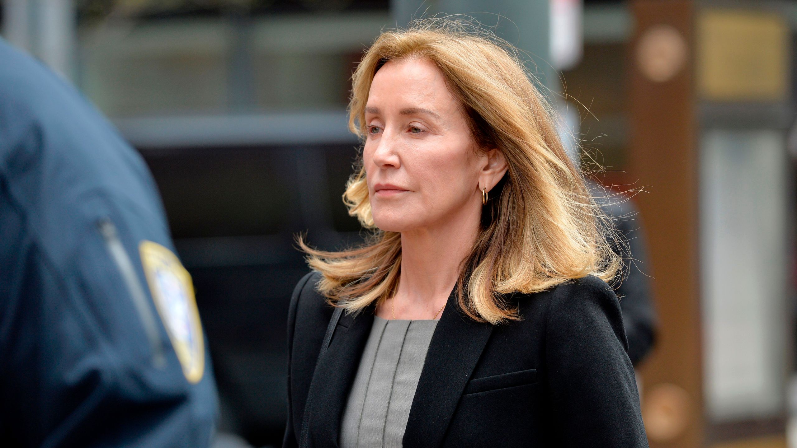 Actress Felicity Huffman is escorted by police into court where she pleaded guilty to one count of conspiracy to commit mail fraud and honest services mail fraud in the college admissions scandal in Boston on May 13, 2019. (Credit: JOSEPH PREZIOSO/AFP/Getty Images)