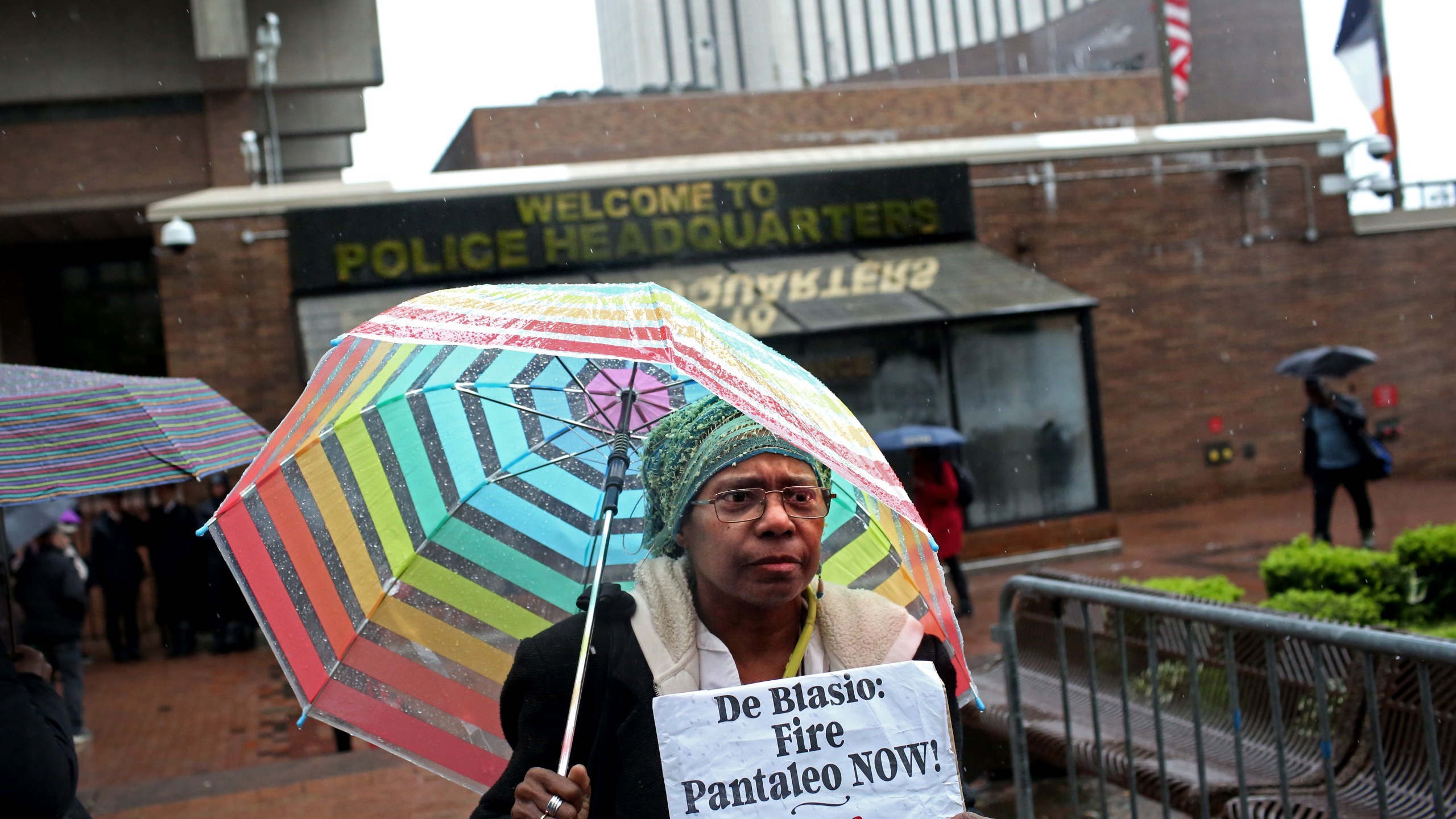 An activist who goes by the name Sista Shirley, 62, from Staten Island, holds up a sign as a line of people awaits entry to the trial of Officer Daniel Pantaleo at One Police Plaza on May 13, 2019 in New York City. (Credit: Yana Paskova/Getty Images)