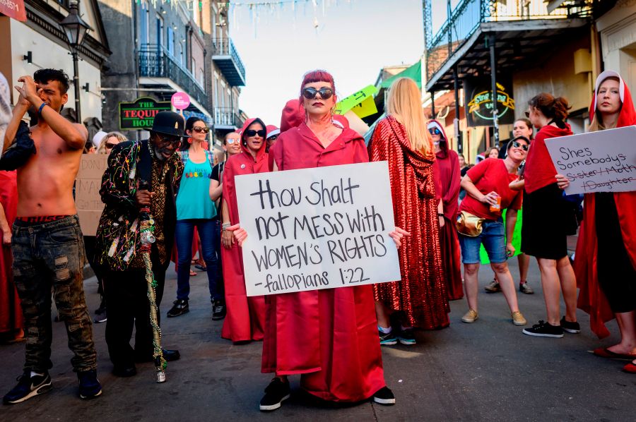 Handmaids-themed protesters march down Bourbon Street in the French Quarter of New Orleans on May 25, 2019. (Credit: EMILY KASK/AFP/Getty Images)