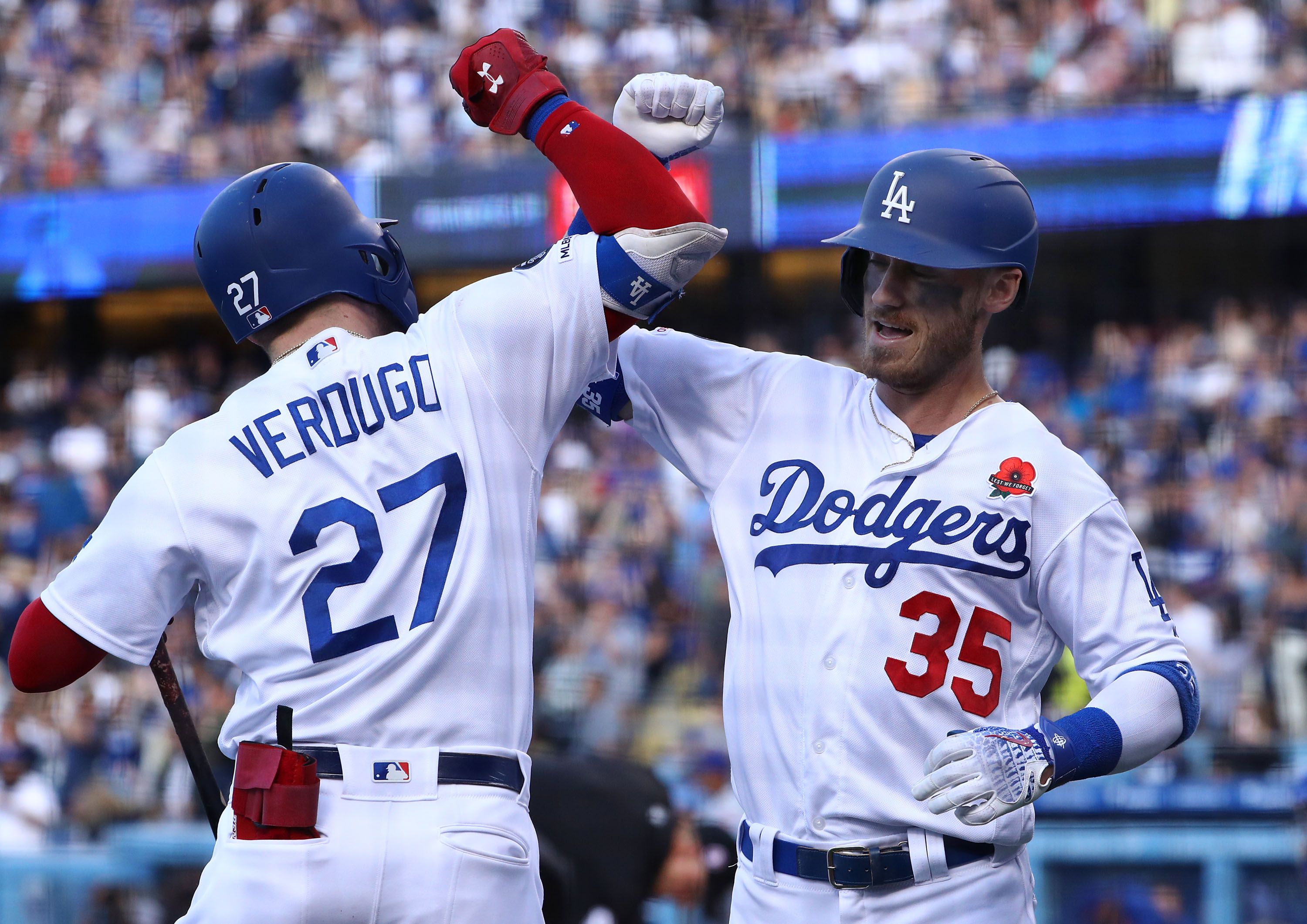 Cody Bellinger, No. 35 of the Los Angeles Dodgers, celebrates with teammate Alex Verdugo, No. 27, after Bellinger hit a solo home run in the third inning of the game against the New York Mets at Dodger Stadium on May 27, 2019. (Credit: Victor Decolongon / Getty Images)