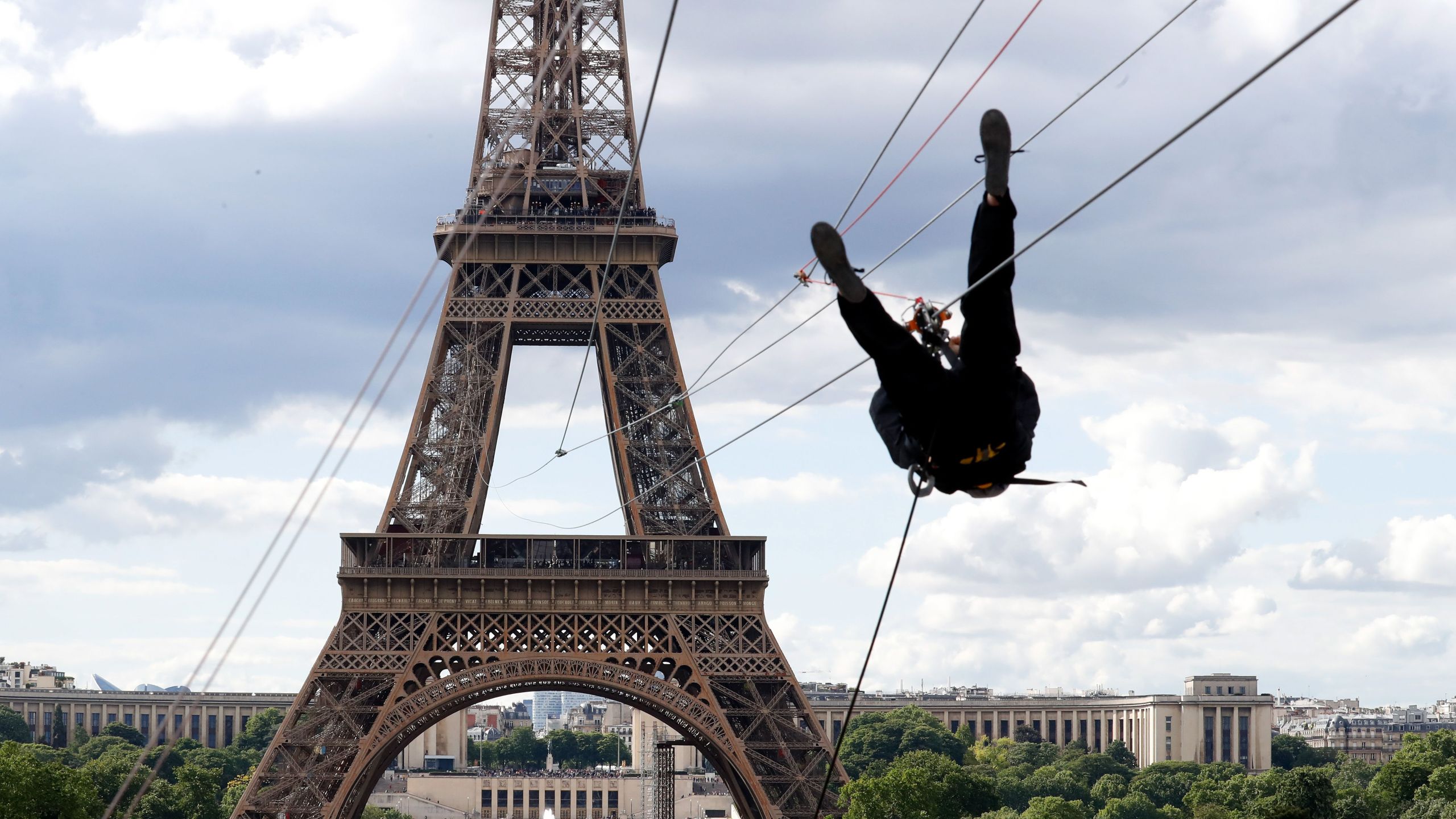 A person rides on a zip-line descending from the second floor of the Eiffel Tower on May 28, 2019 in Paris. (Credit: FRANCOIS GUILLOT/AFP/Getty Images)