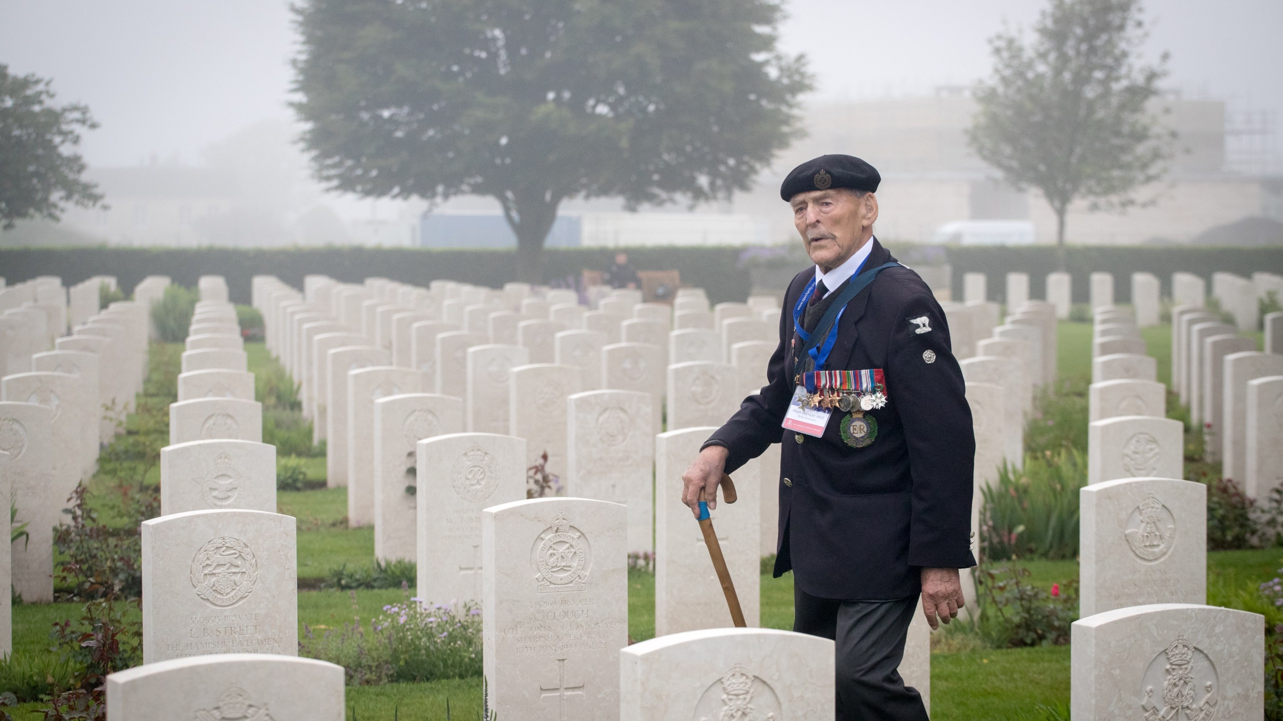 Normany veteran 98-year-old Edwin 'Ted' Hunt walks past the graves of the fallen as Normandy veterans attend a official service of remembrance at Bayeux Cemetery during the D-Day 74th anniversary commemorations in Normandy on June 6, 2018 in Bayeux, France. (Credit: Matt Cardy/Getty Images)