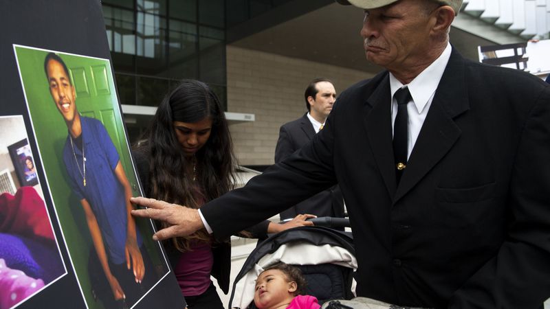 John Weber touches a photo of his son Anthony Weber in 2018. (Credit: Kent Nishimura / Los Angeles Times)