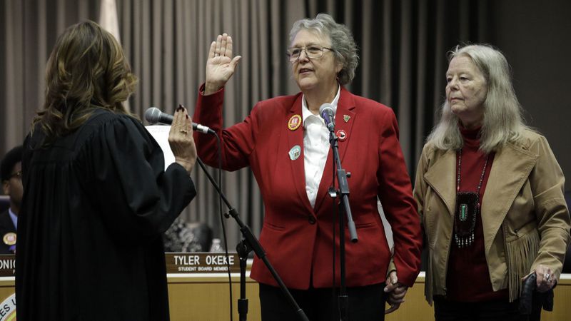 Jackie Goldberg, standing with wife Sharon Stricker, takes the oath of office Tuesday as an L.A. school board member from retired Judge Teresa Sanchez-Gordon. Goldberg had an immediate impact. (Credit: Myung J. Chun / Los Angeles Times)