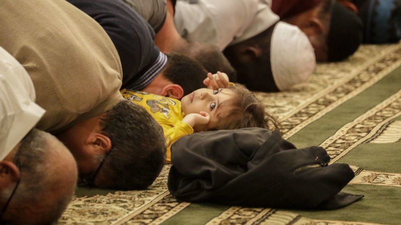 A child plays as men offer their nightly Ramadan prayers at Masjid Al-Fatiha in 2018. (Credit: Irfan Khan / Los Angeles Times)