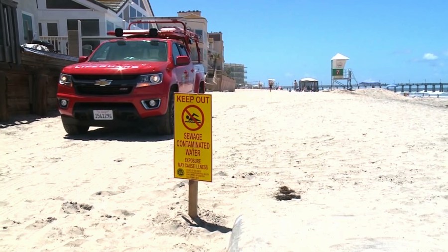 A sign warning beachgoers to keep out of the water at Imperial Beach is posted on May 27, 2019, after contaminated runoff flowed into the area from Mexico's Tijuana River. (Credit: KSWB via CNN)