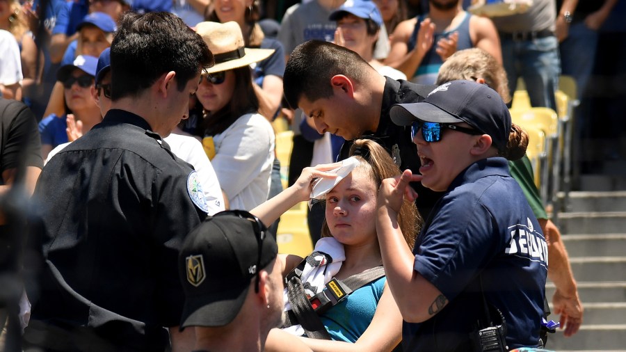 Kaitlyn Salazar, 13, puts an ice pack to her head after she was hit by a foul ball off the bat of Cody Bellinger #35 of the Los Angeles Dodgers during the first inning against the Colorado Rockies at Dodger Stadium on June 23, 2019 in Los Angeles, California. (Credit: Harry How/Getty Images)