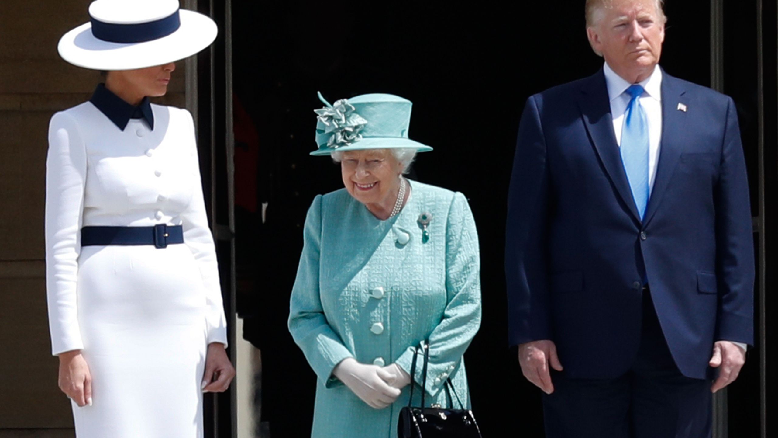 Britain's Queen Elizabeth II (C) stands with US President Donald Trump (R) as US First Lady Melania Trump (L) during a welcome ceremony at Buckingham Palace in central London on June 3, 2019. (Credit: ADRIAN DENNIS/AFP/Getty Images)