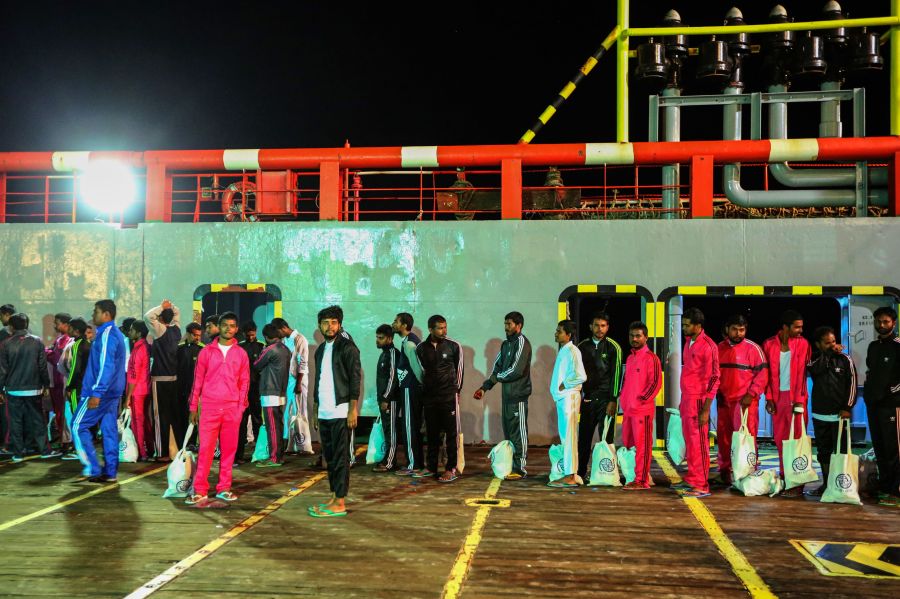 Migrants walk along the dock after disembarking from a vessel as ay arrive to Zarzis harbour in a souarn coast of Tunisia on June 18, 2019. (Credit: FATHI NASRI/AFP/Getty Images)