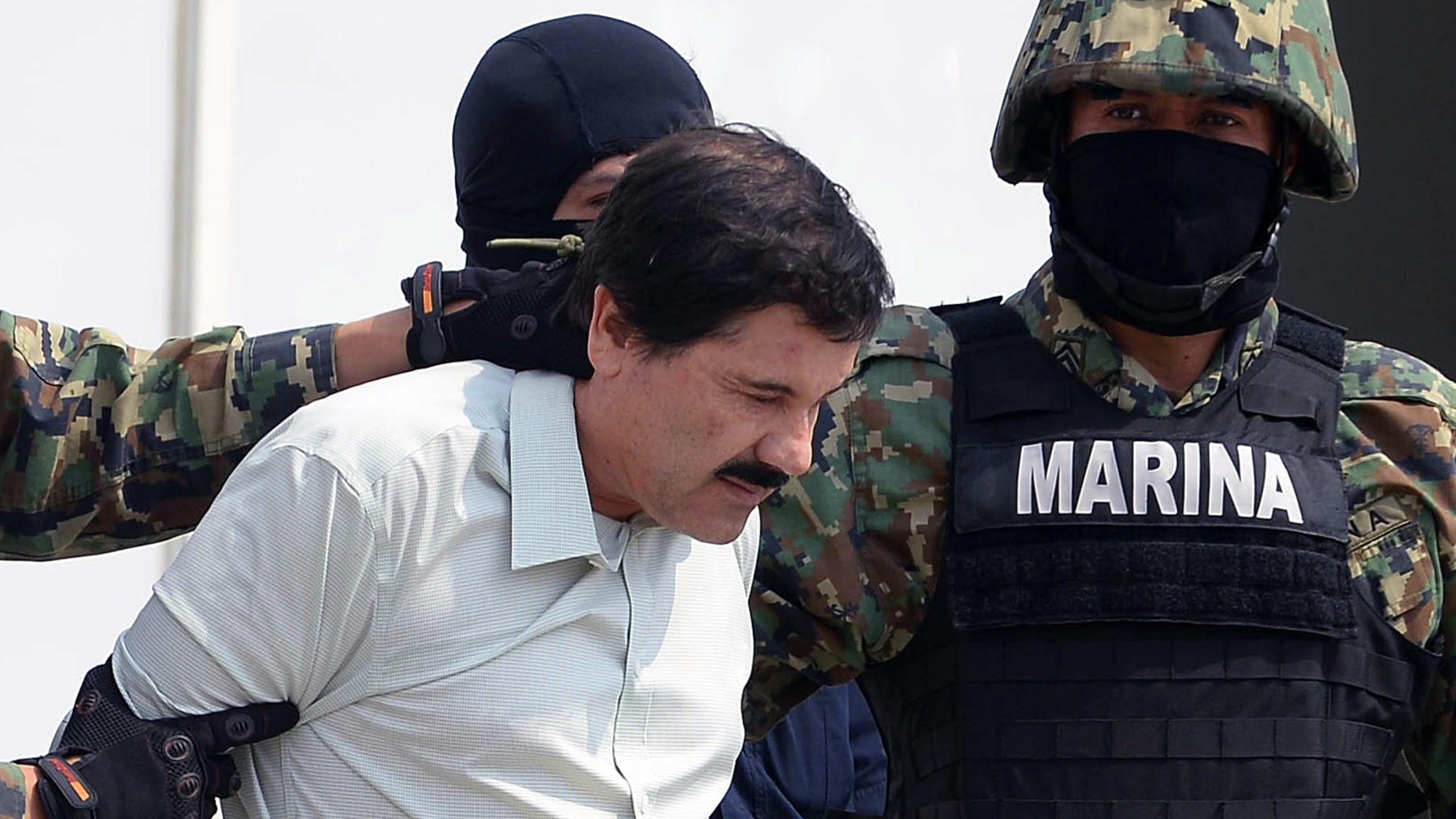 Mexican drug trafficker Joaquin Guzman Loera aka "el Chapo Guzman", is escorted by marines as he is presented to the press on February 22, 2014 in Mexico City. (Credit: ALFREDO ESTRELLA/AFP/Getty Images)