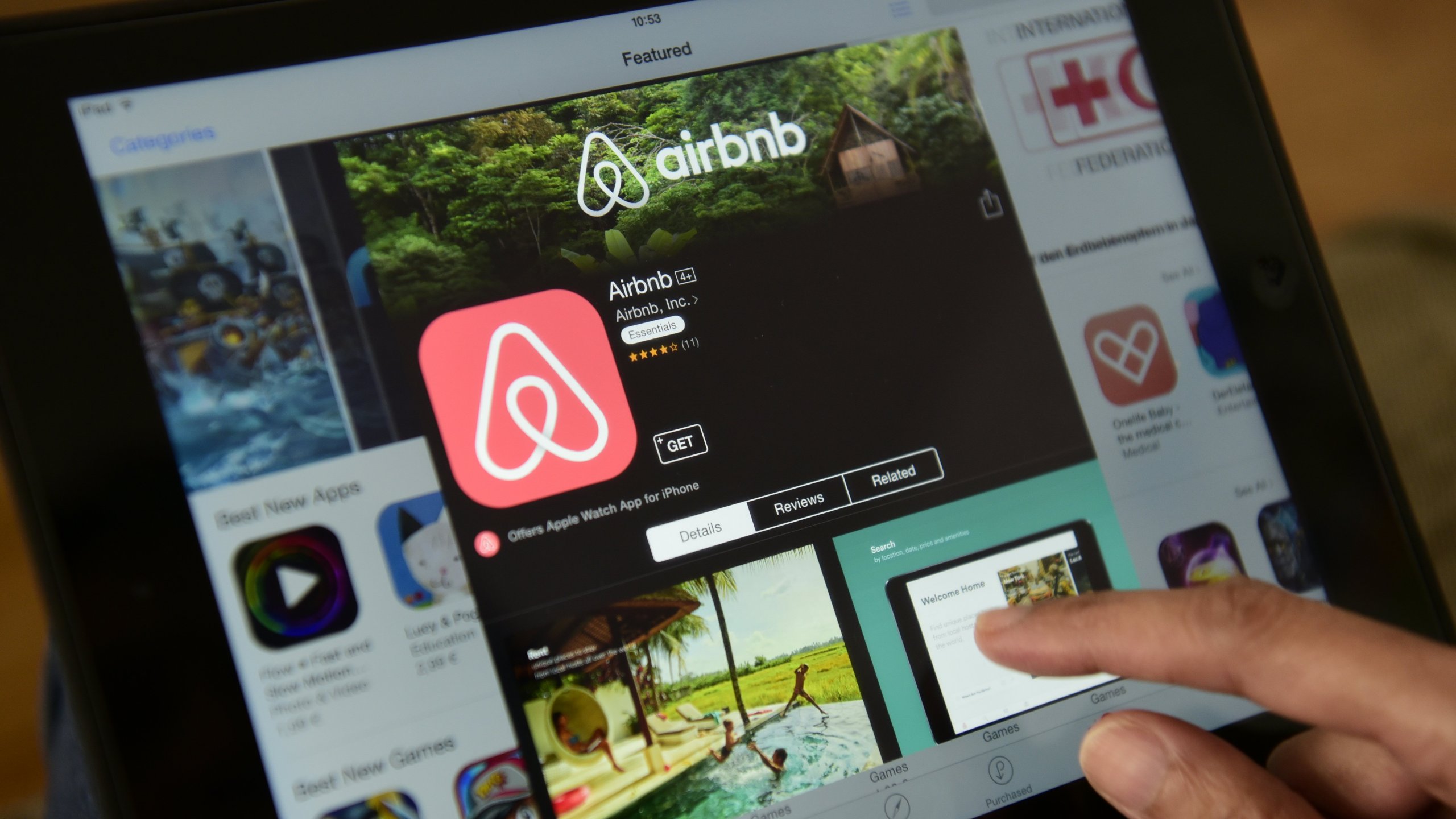 A woman browses the site of US home sharing giant Airbnb on a tablet in Berlin on April 28, 2016. (Credit: JOHN MACDOUGALL/AFP/Getty Images)