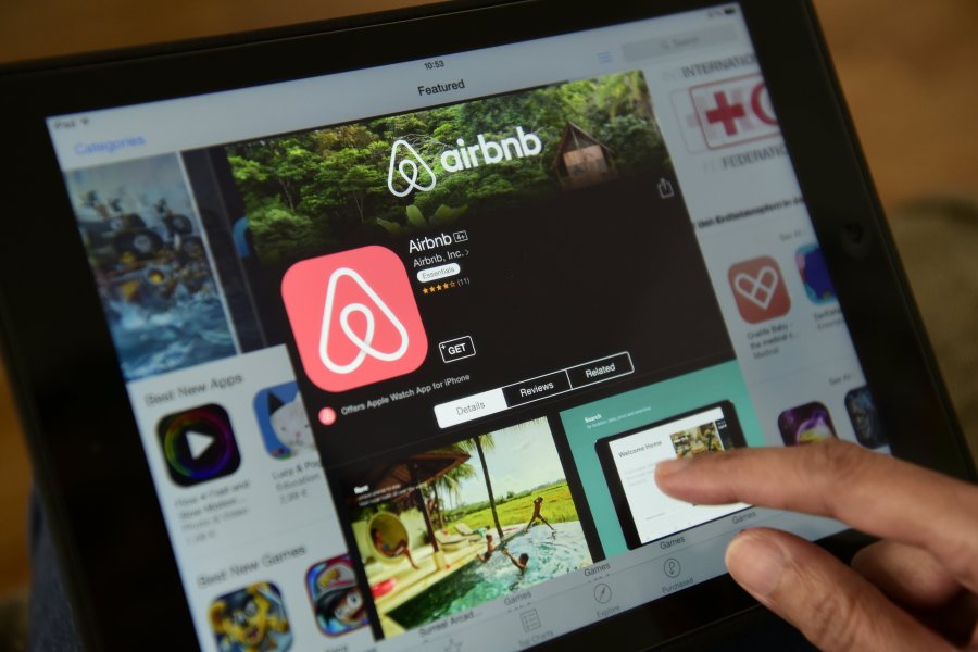 A woman browses the site of US home sharing giant Airbnb on a tablet in Berlin on April 28, 2016. (Credit: JOHN MACDOUGALL/AFP/Getty Images)