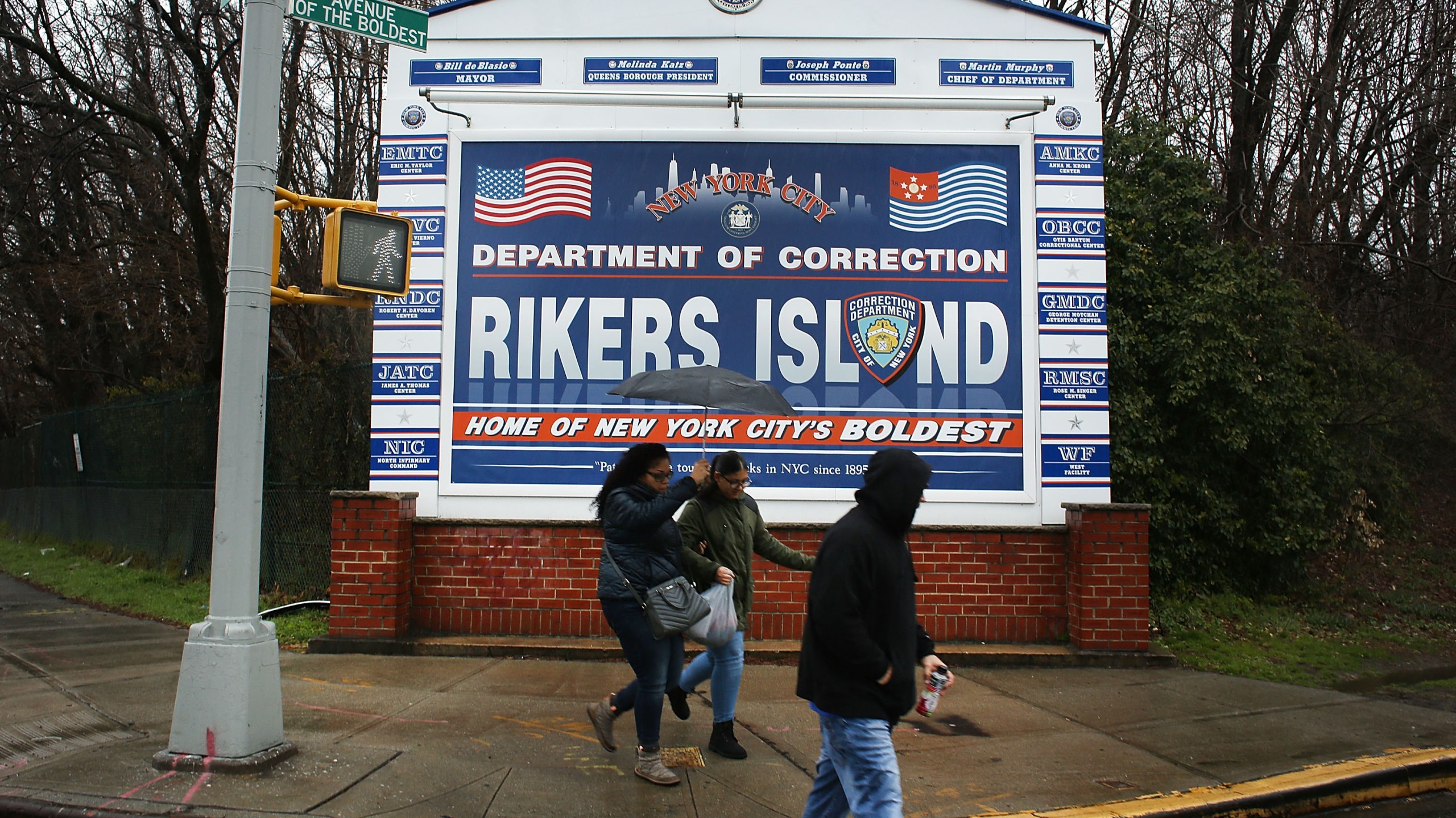 People walk by a sign at the entrance to Rikers Island on March 31, 2017 in New York City. (Credit: Spencer Platt/Getty Images)