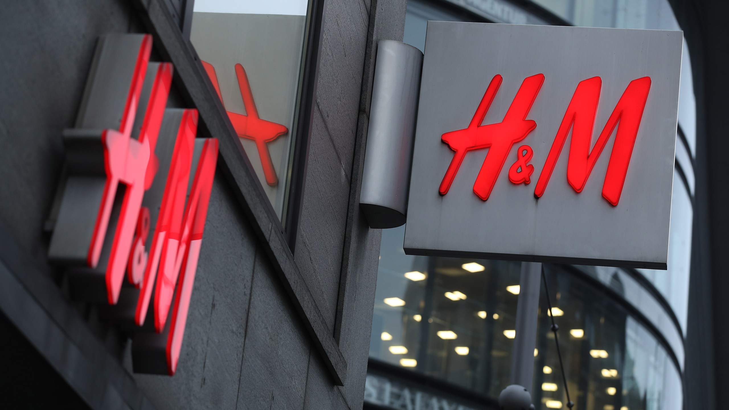 The logo of Swedish clothing retailer H&M hangs over one of its stores on March 28, 2018 in Berlin, Germany. (Credit: Sean Gallup/Getty Images)