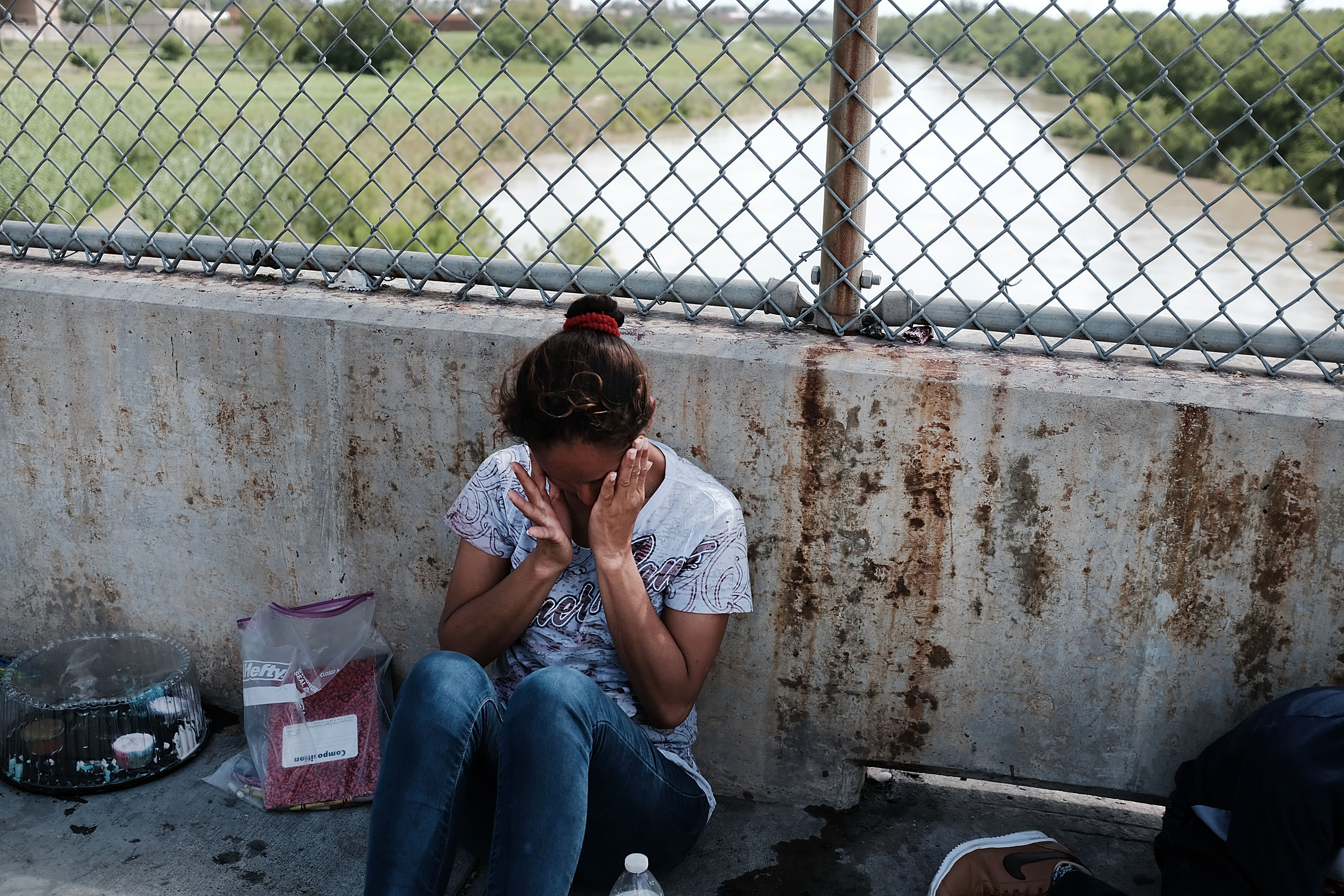 A Honduran woman, fleeing poverty and violence in her home country, waits along the border bridge after being denied entry into the U.S. from Mexico on June 25, 2018, in Brownsville, Texas. (Credit: Spencer Platt/Getty Images)