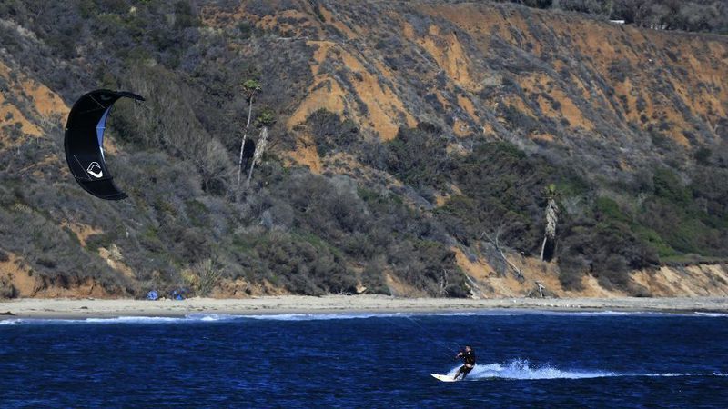 A kite surfer rides a gust of wind along the coastline at Leo Carrillo State Park in Malibu in 2016. (Credit: Allen J. Schaben / Los Angeles Times)