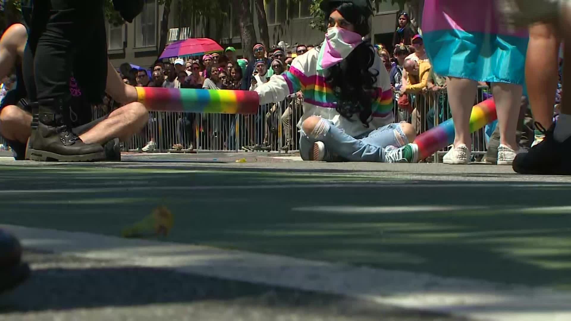 Protesters link arms while dressed in rainbow colors as they block a street during Pride festivities in San Francisco on June 30, 2019. (Credit: CNN)