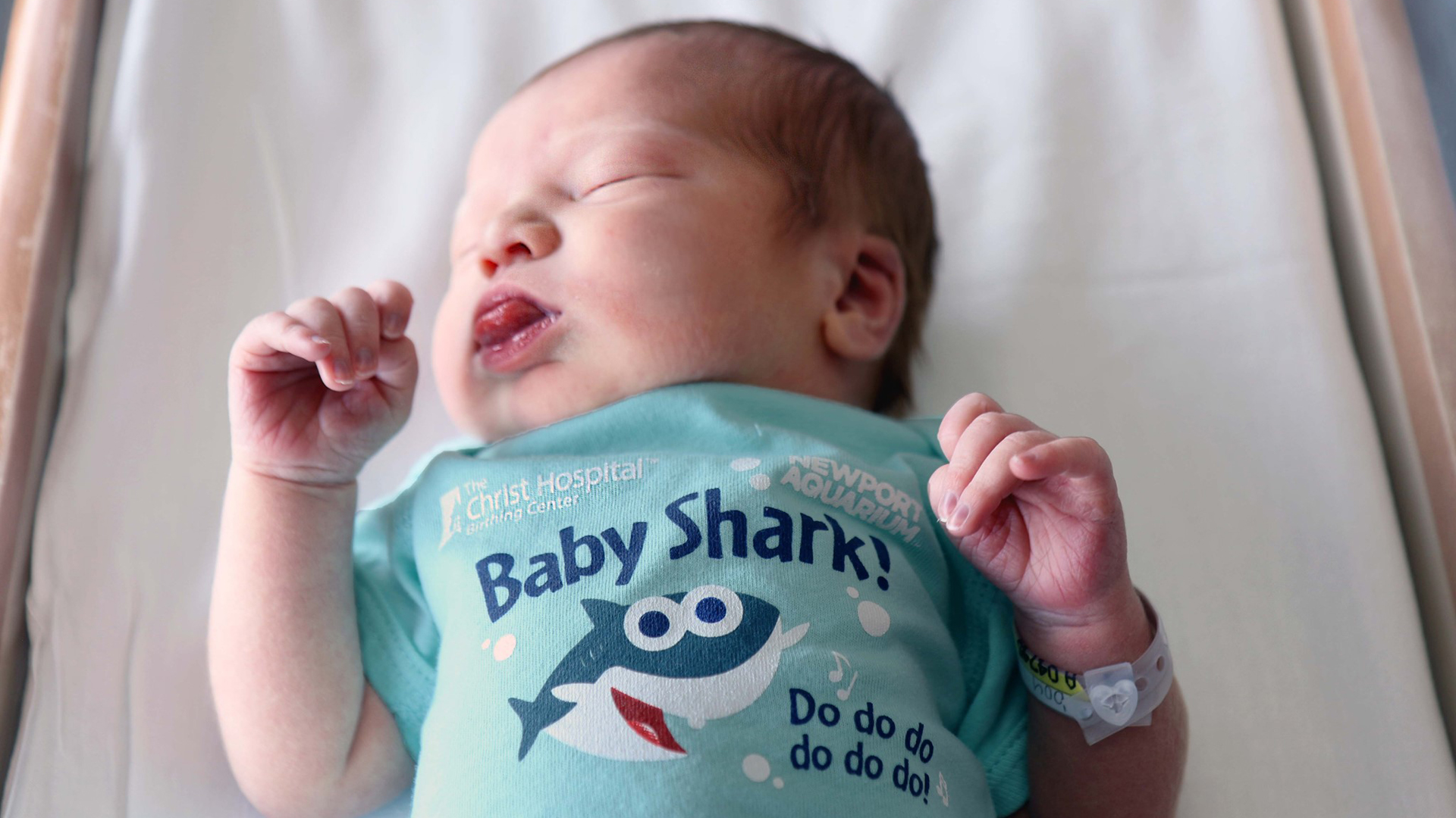 A baby in a baby shark onesie is seen in this image from The Christ Hospital Health Network.