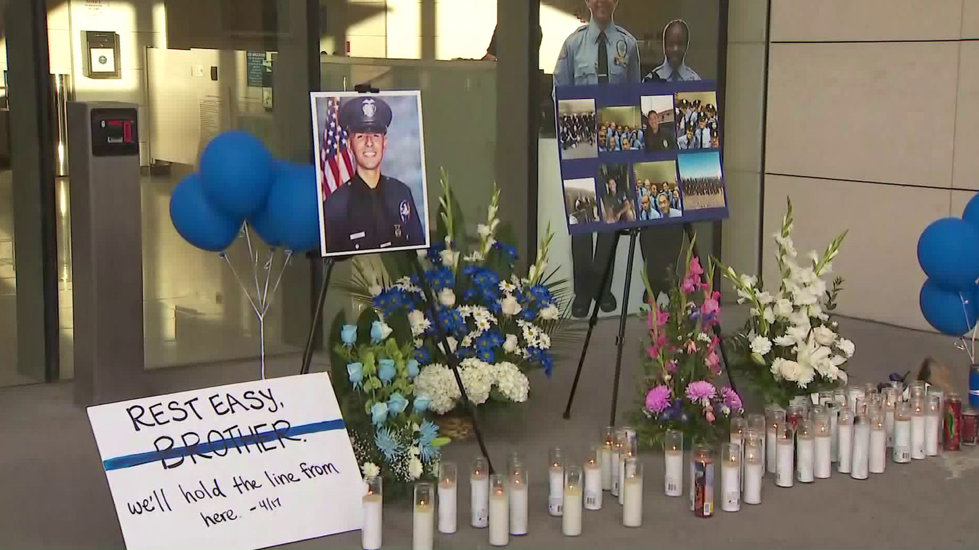 Candles, photos, balloons, flowers and a sign that reads "Rest easy brother, we'll hold the line from here," appear outside LAPD's headquarters in honor of Officer Juan Diaz on July 28, 2019. (Credit: KTLA)