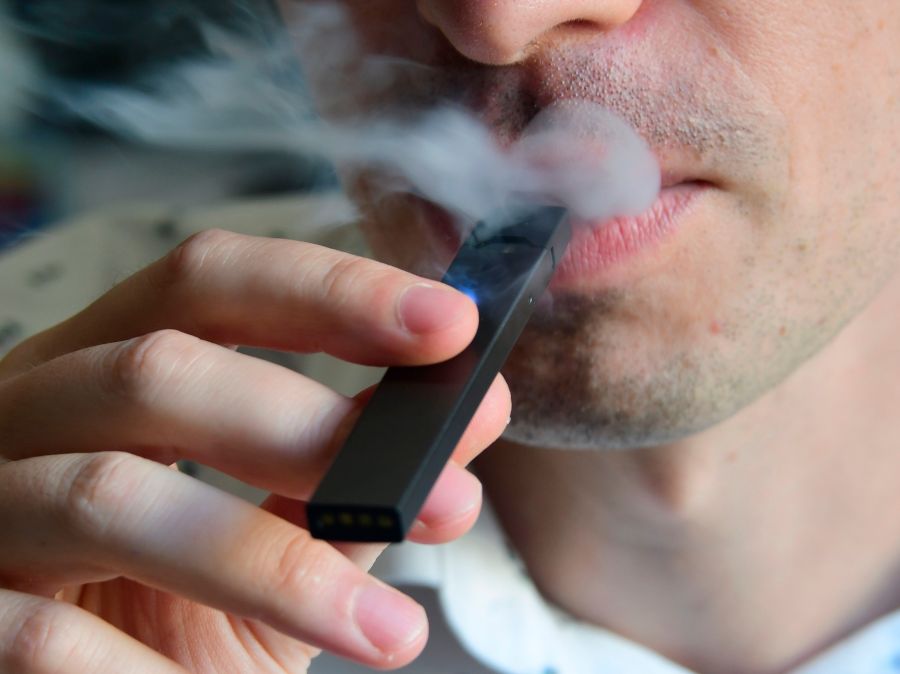 An illustration shows a man exhaling smoke from an electronic cigarette in Washington, DC on Oct. 2, 2018.(Credit: Eva Hambach/AFP/Getty Images)