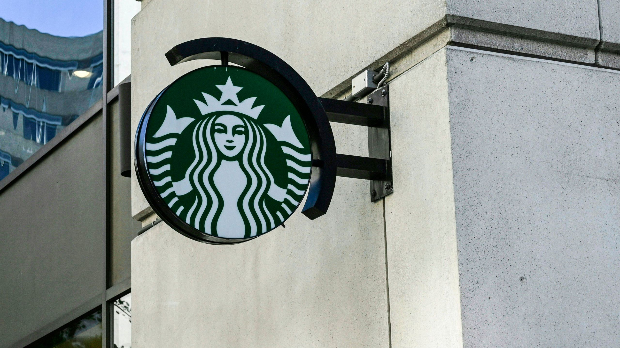 A Starbucks logo hangs over a store entrance in Washington, DC on June 11, 2019. (Credit: Eva Hambach/AFP/Getty Images)