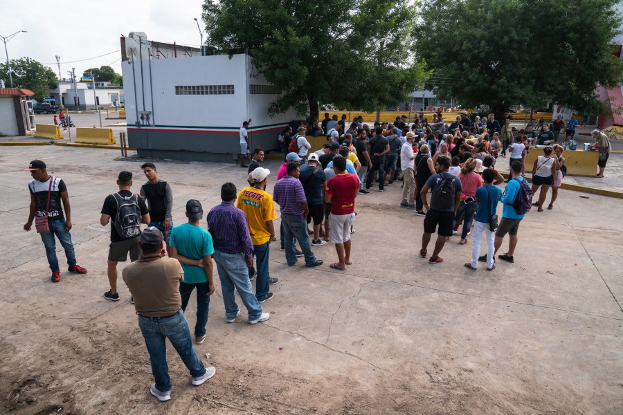 Asylum-seekers wait in line to get a meal close to the International Bridge near a section where a father and daughter drowned attempting to cross into the United States on June 26, 2019 in Matamoros, Tamaulipas. (Credit: Verónica G. Cárdenas/Getty Images)