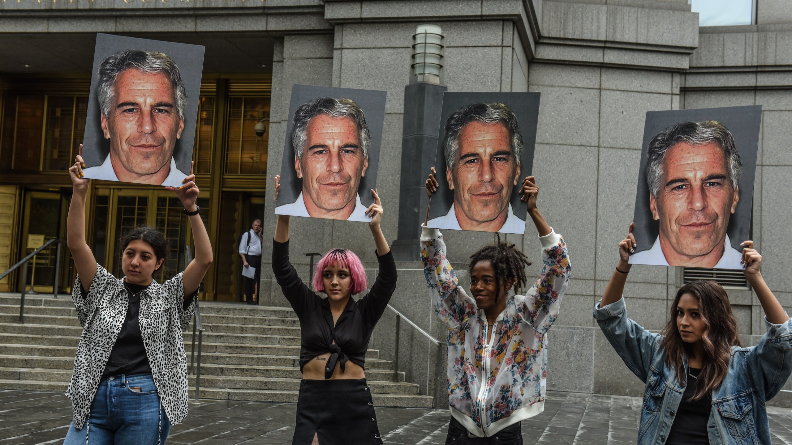 Protesters hold up photos of Jeffrey Epstein in front of the Federal courthouse on July 8, 2019 in New York City. (Credit: Stephanie Keith/Getty Images)