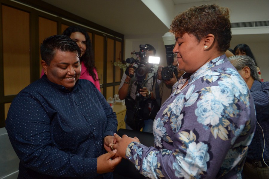 Alexandra Chavez (left) places a ring on the finger of Michelle Aviles during Ecuador's first same sex marriage at a registry office in Guayaquil on July 18, 2019. (Credit: MARCOS PIN/AFP/Getty Images)