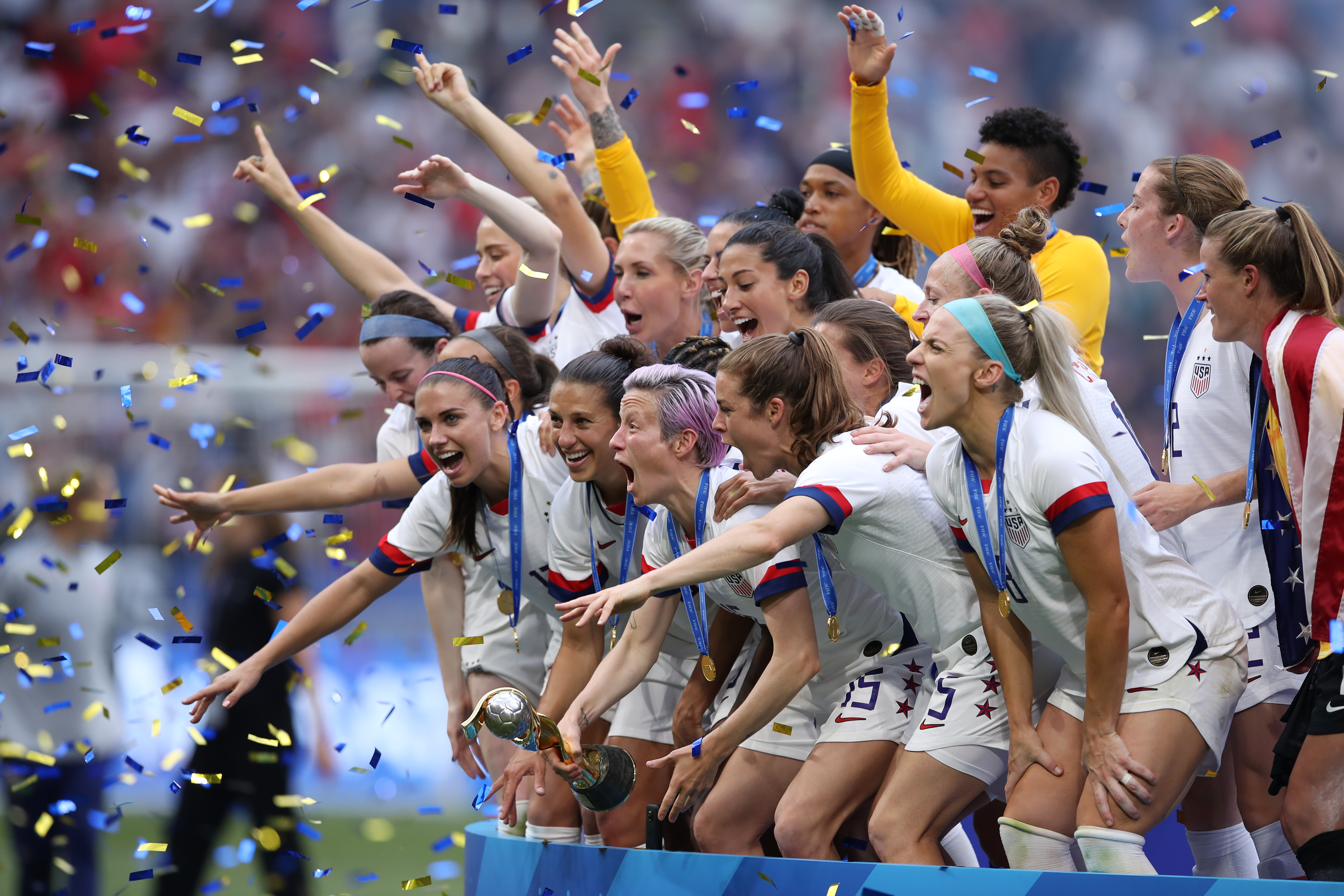 Megan Rapinoe lifts the FIFA Women's World Cup trophy following her team's victory in the 2019 FIFA Women's World Cup final on July 7, 2019 in Lyon, France. (Credit: Alex Grimm/Getty Images)