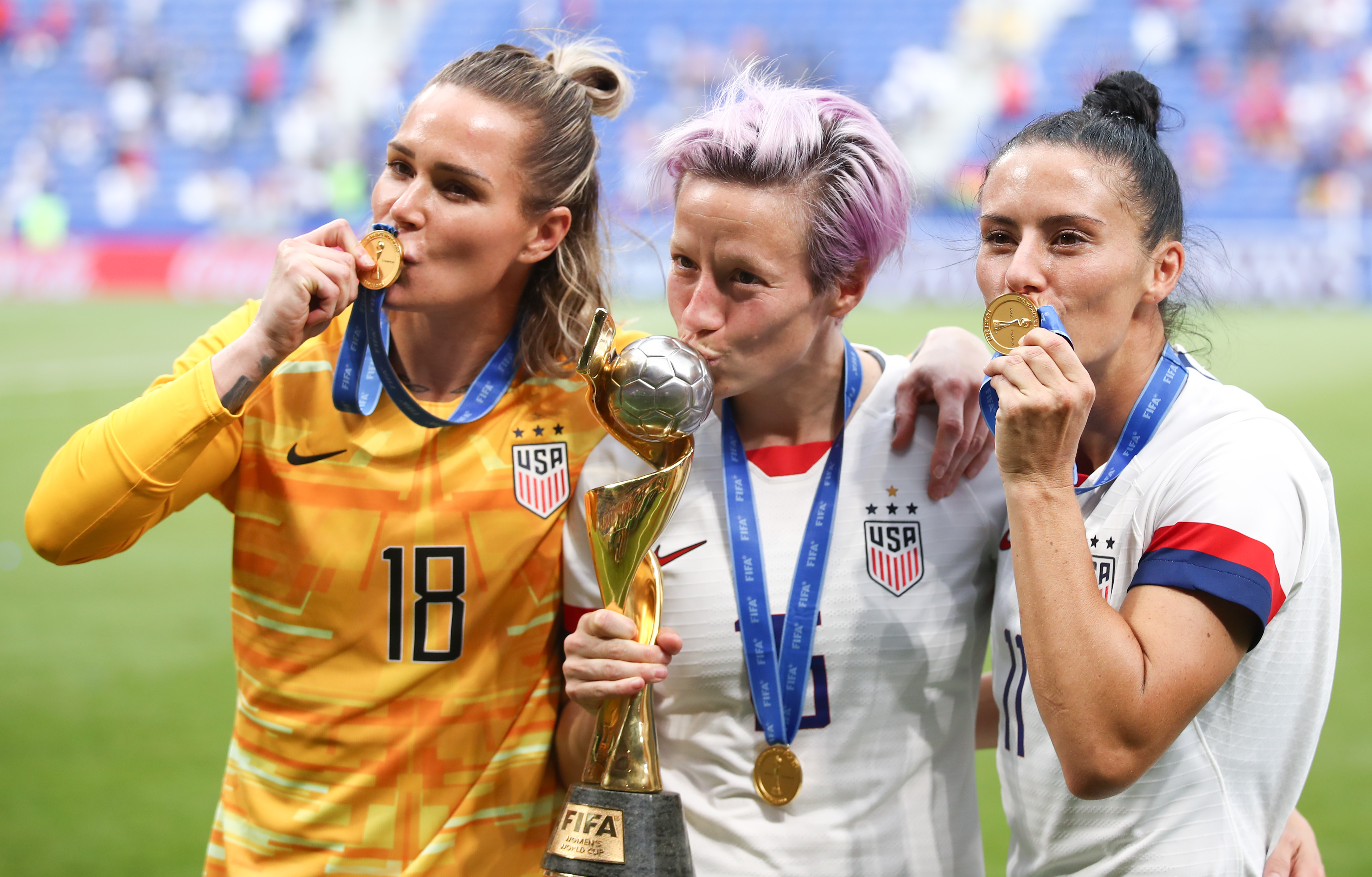 Ashlyn Harris, Megan Rapinoe and Ali Krieger of the U.S.A. Women's Soccer Team celebrate with the FIFA Women's World Cup Trophy following the 2019 FIFA Women's World Cup France Final match between the U.S. and the Netherlands at Stade de Lyon on July 7, 2019, in Lyon, France. (Credit: Alex Grimm/Getty Images)