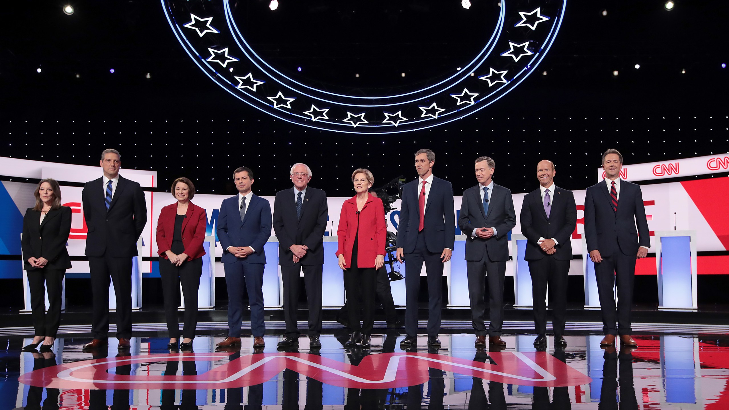 From left: Democratic presidential candidates Marianne Williamson, Rep. Tim Ryan, Sen. Amy Klobuchar, Indiana Mayor Pete Buttigieg, Sen. Bernie Sanders, Sen. Elizabeth Warren, former Texas congressman Beto O'Rourke, former Colorado governor John Hickenlooper, former Maryland congressman John Delaney and Montana Gov. Steve Bullock take the stage at the beginning of a CNN-hosted in Detroit on July 30, 2019. (Credit: Scott Olson / Getty Images)