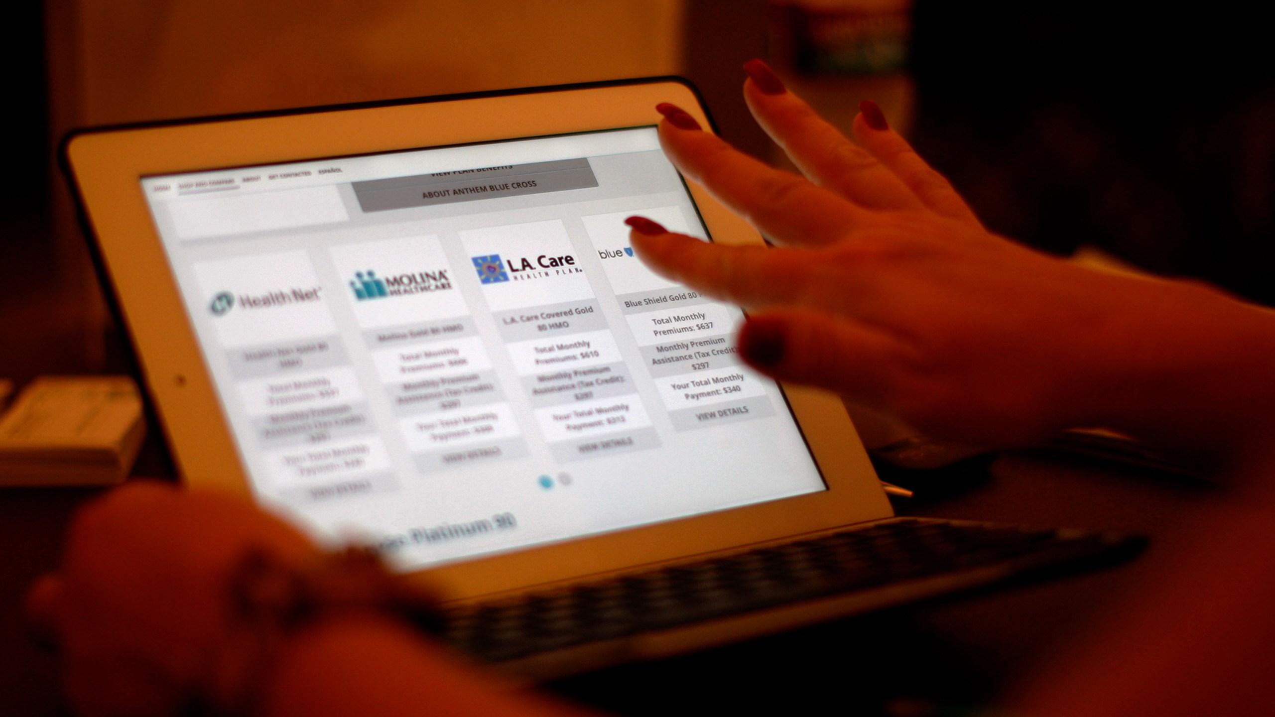 A health care reform specialist helps people select insurance plans at an enrollment fair at Pasadena City College on Nov. 19, 2013. (David McNew/Getty Images)