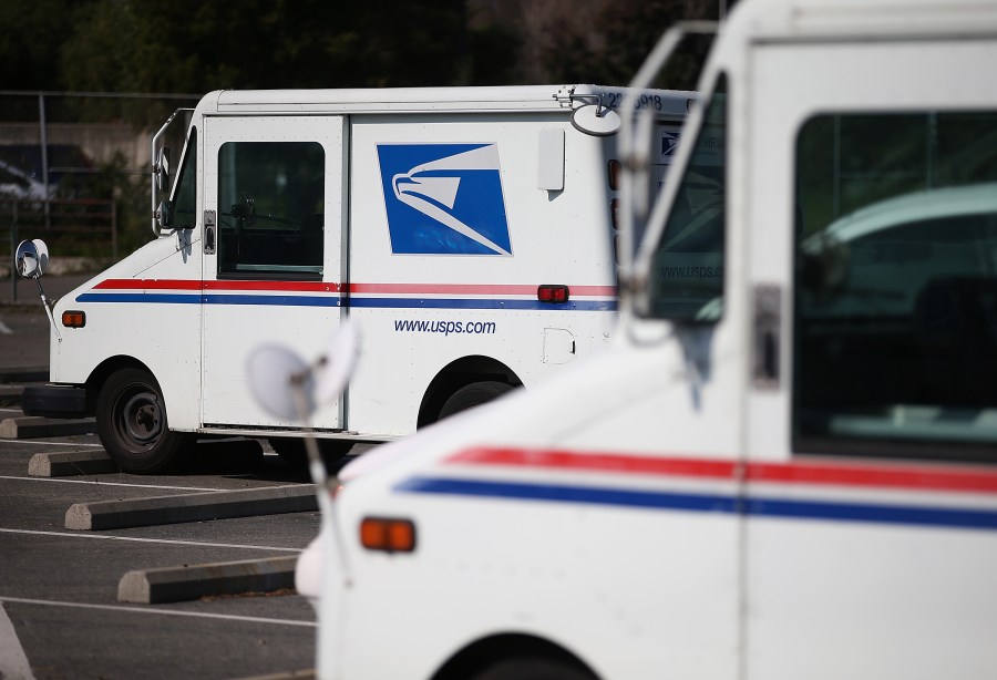 U.S. Postal Service mail trucks sit in a parking lot at a distribution center in San Francisco on Feb. 18, 2015. (Justin Sullivan / Getty Images)