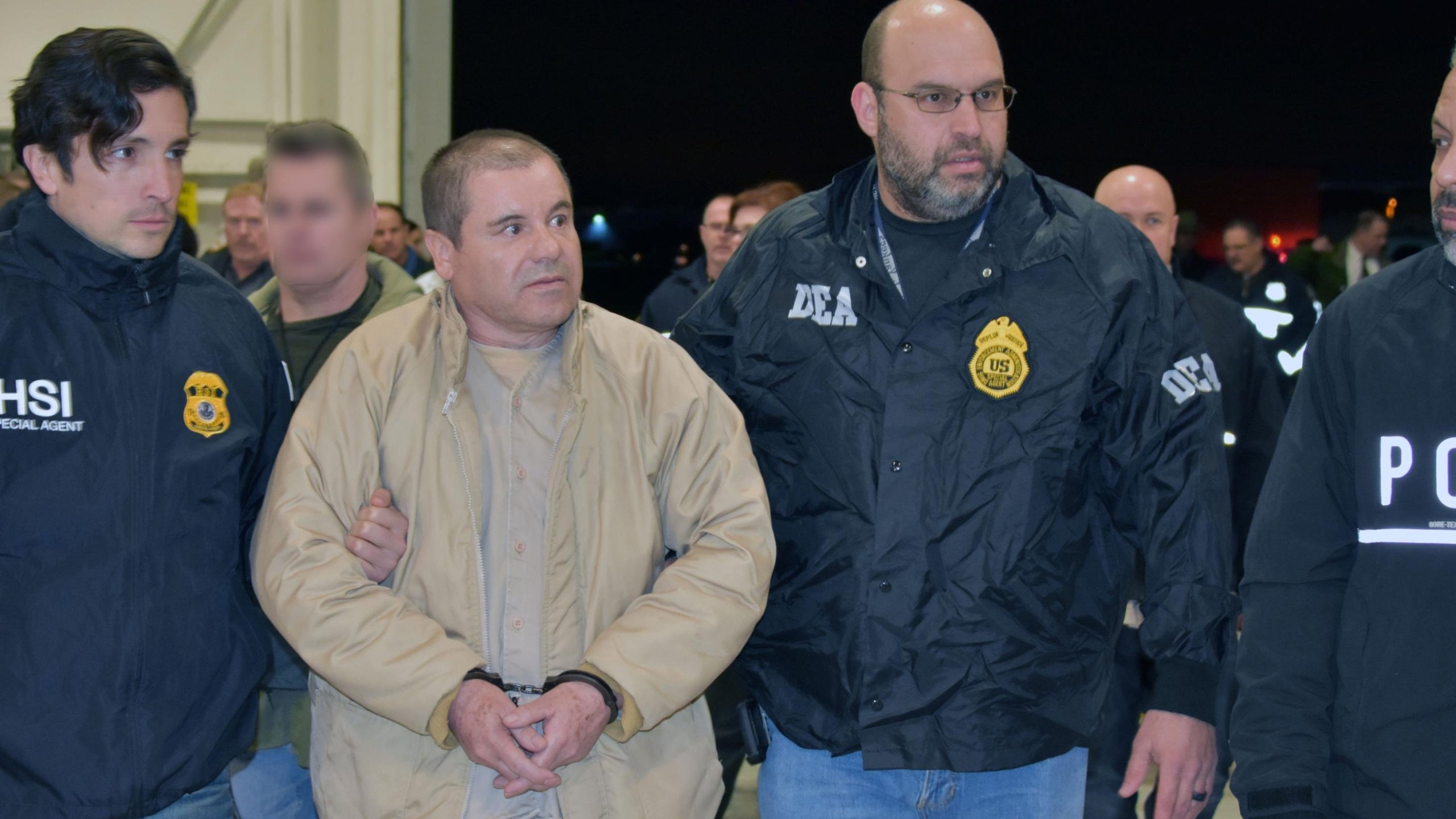 Convicted drug kingpin Joaquin "El Chapo" Guzman is escorted by federal agents as he's extradited to the U.S. on Feb. 19, 2019, in this handout photo from the Department of Justice.