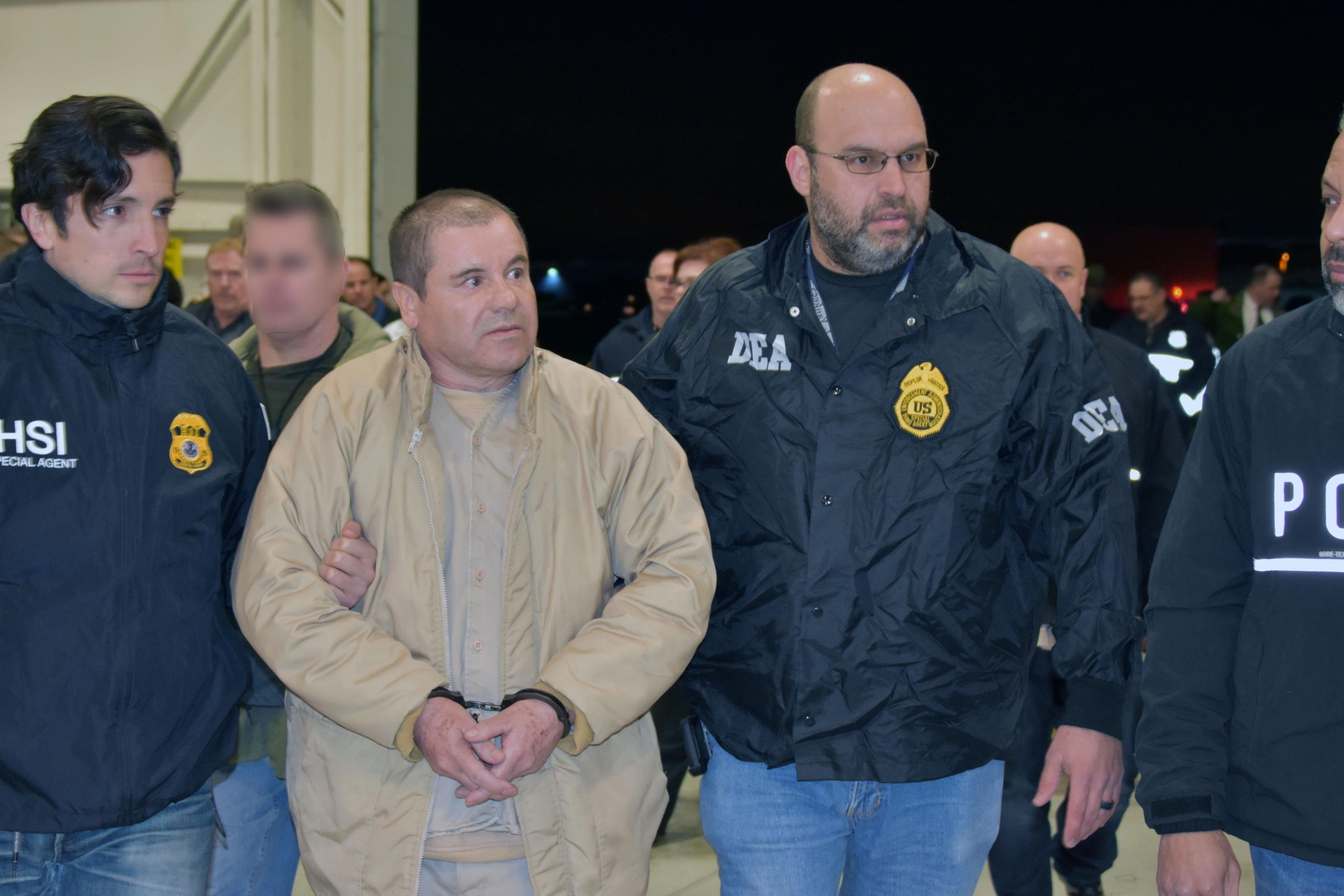 Convicted drug kingpin Joaquin "El Chapo" Guzman is escorted by federal agents as he's extradited to the U.S. on Feb. 19, 2019, in this handout photo from the Department of Justice.