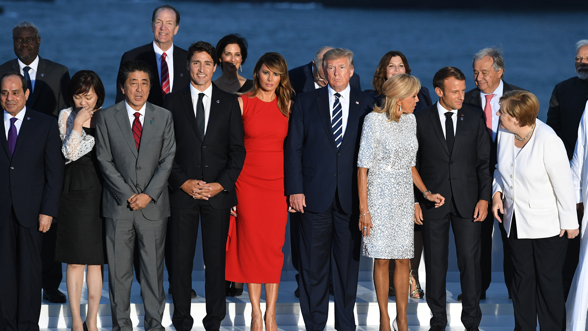 African Union Chair Egyptian President Abdel Fattah el-Sisi, Japanese Prime Minister's wife Akie Abe, Japan's Prime Minister Shinzo Abe, Canada's Prime Minister Justin Trudeau, US First Lady Melania Trump, US President Donald Trump, French President's wife Brigitte Macron, France's President Emmanuel Macron and Germany's Chancellor Angela Merkel join G7 leaders and guests as they gather for a family picture in front of the Biarritz lighthouse on the second day of the annual G7 summit on August 25, 2019 in Biarritz, France.