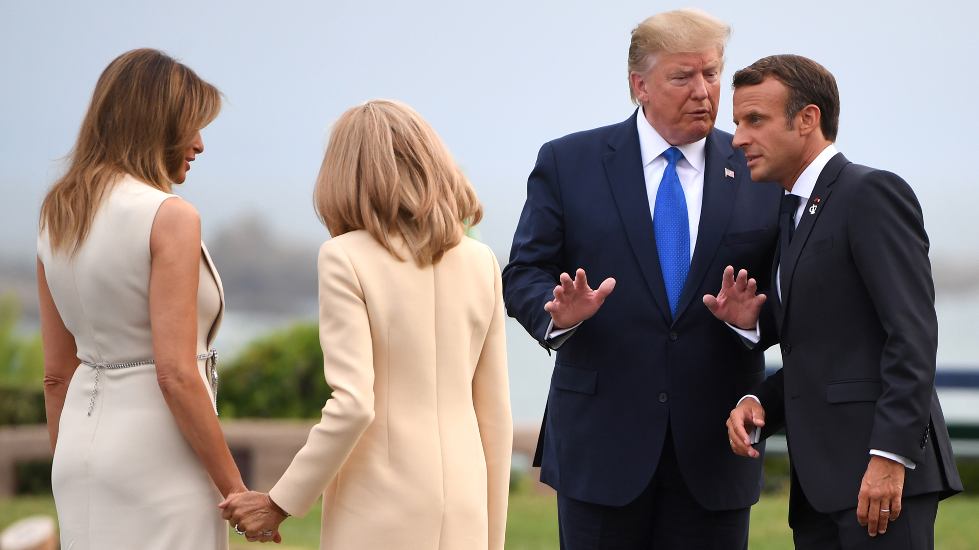 French President Emmanuel Macron (R) and his wife Brigitte Macron (2nd L) welcome US President Donald Trump (2nd R) and his wife US First Lady Melania Trump (L) ahead of a working dinner at the Biarritz lighthouse on August 24, 2019 in Biarritz, France. (Credit: Neil Hall - Pool/Getty Images)