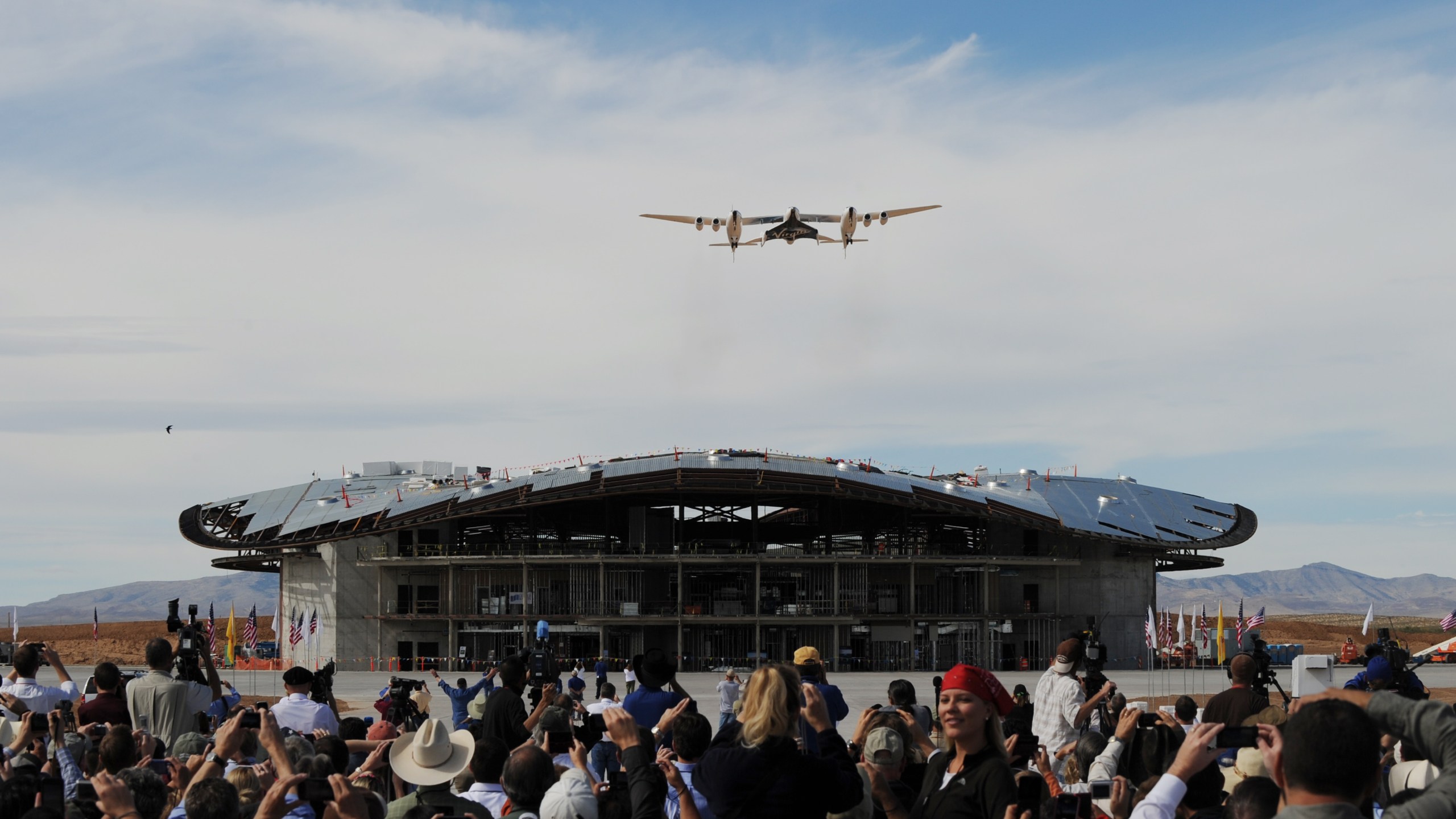 The Virgin Galactic VSS Enterprise spacecraft flies over its hanger before its first public landing during the Spaceport America runway dedication ceremony near Las Cruces, New Mexico on October 22, 2010. (Credit: MARK RALSTON/AFP/Getty Images)