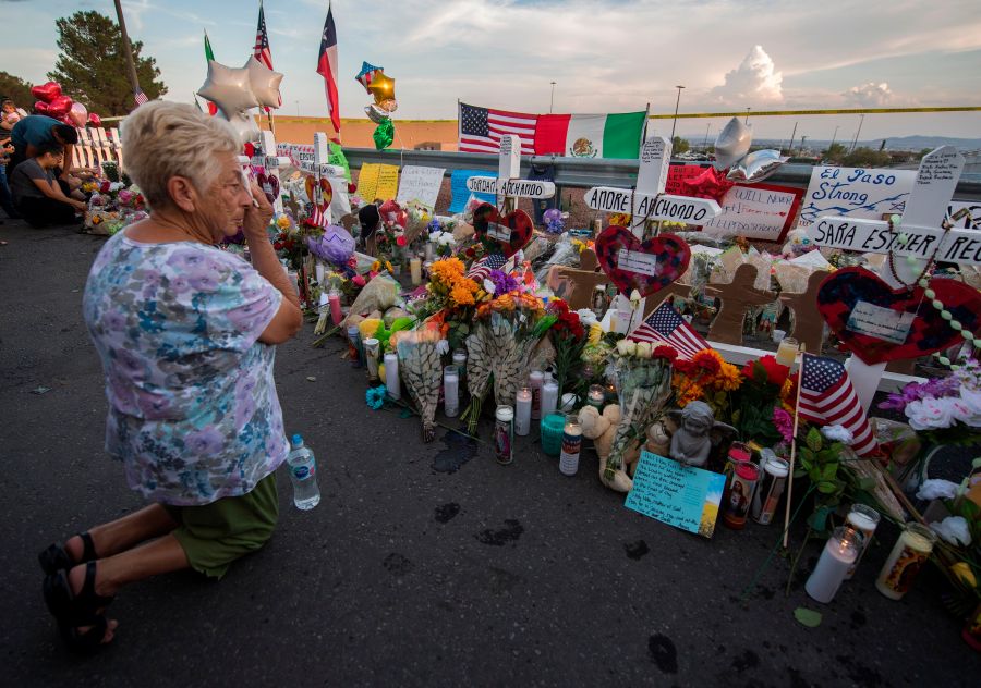 A woman prays at a makeshift memorial for victims of Walmart shooting that left a total of 22 people dead at the Cielo Vista Mall WalMart in El Paso, Texas, sometime in the days after the massacre on Aug. 5, 2019. (Credit: MARK RALSTON/AFP/Getty Images)