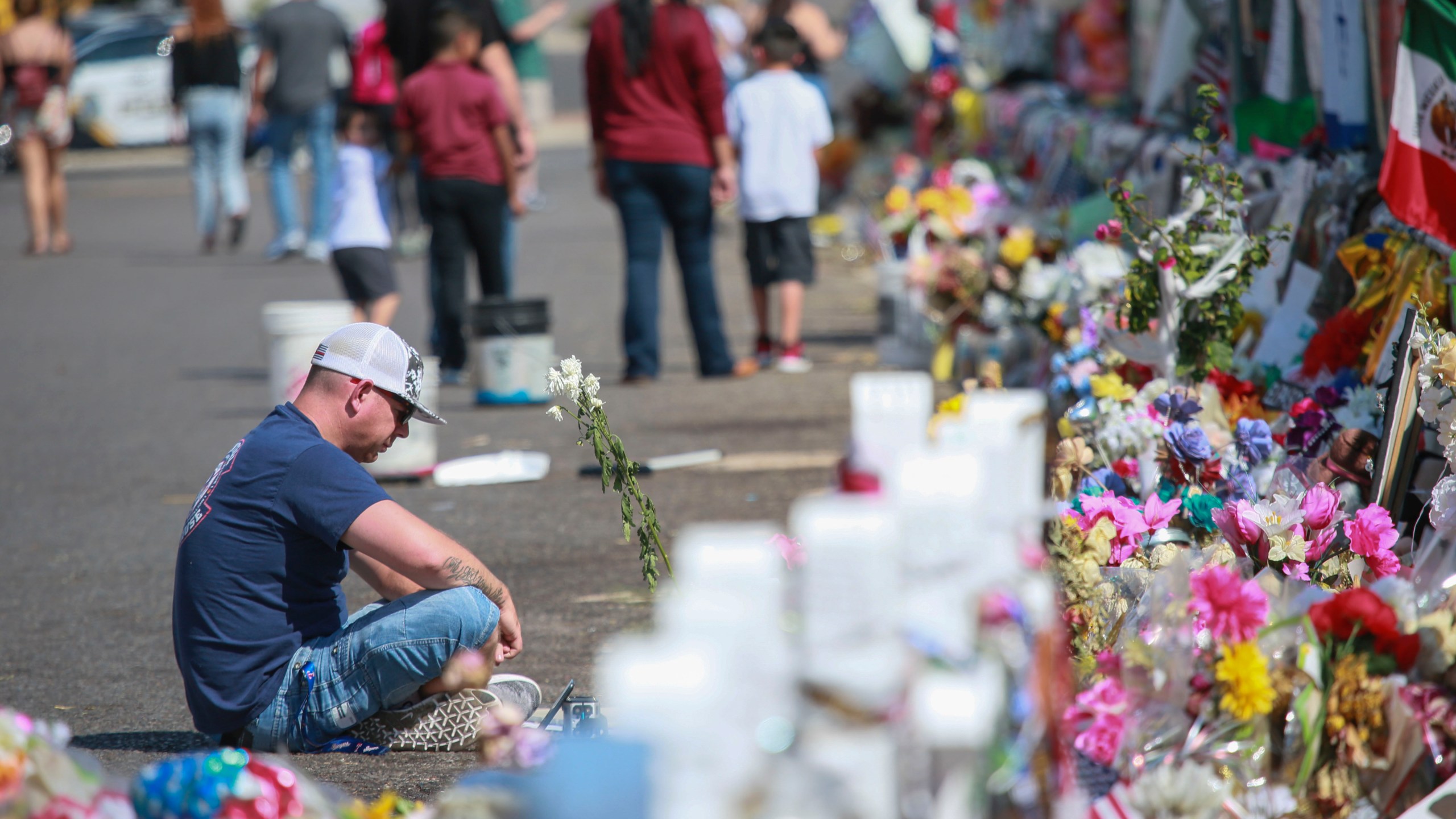 People gather at a makeshift memorial honoring victims outside Walmart in El Paso on Aug. 15, 2019.(Credit: Sandy Huffaker / Getty Images)