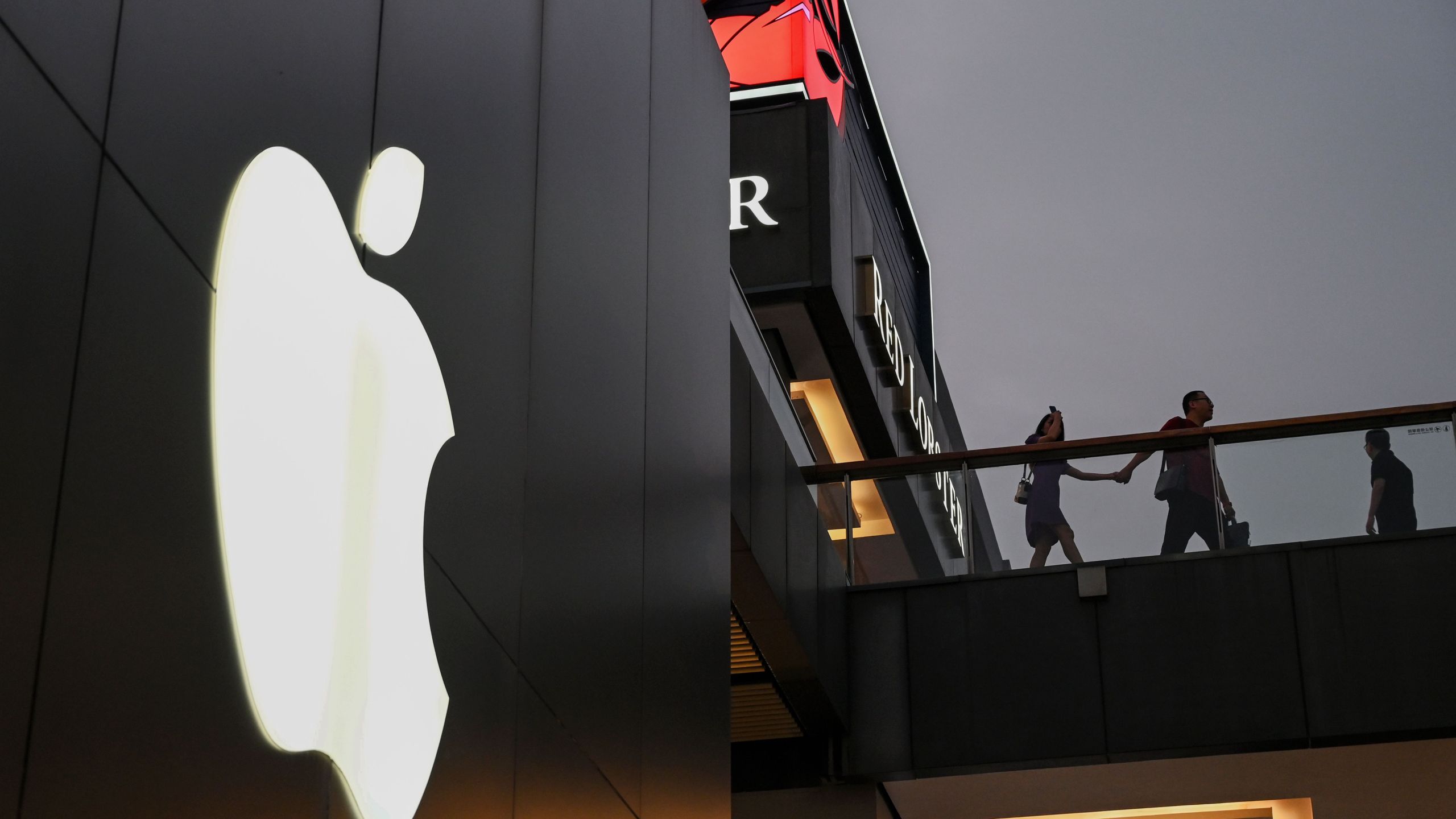 People walk past an Apple store in Beijing on August 26, 2019. (Credit: GREG BAKER/AFP/Getty Images)